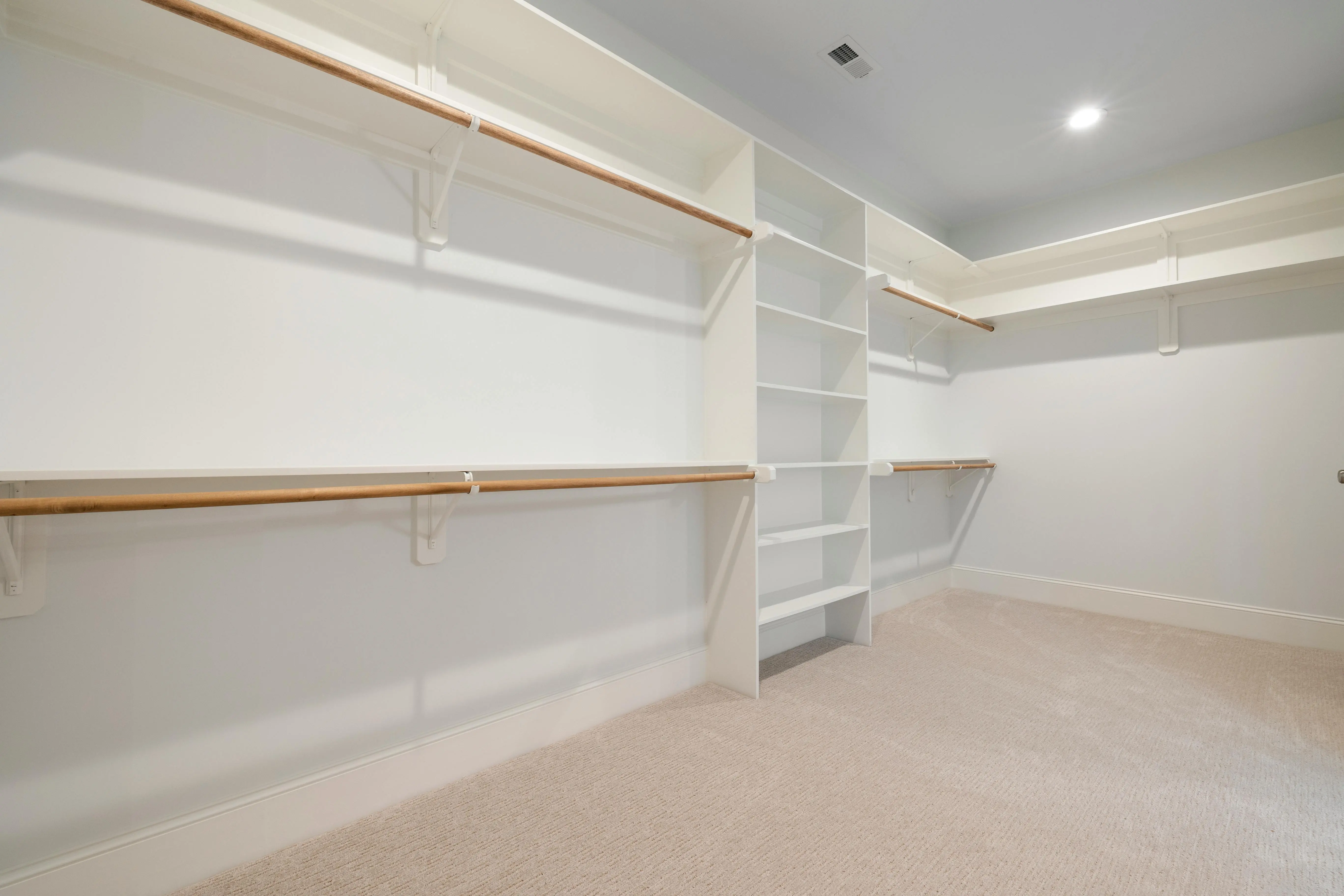 shelf and rod bracket Modern empty walk-in closet with ample shelves and hanging rods for storage.