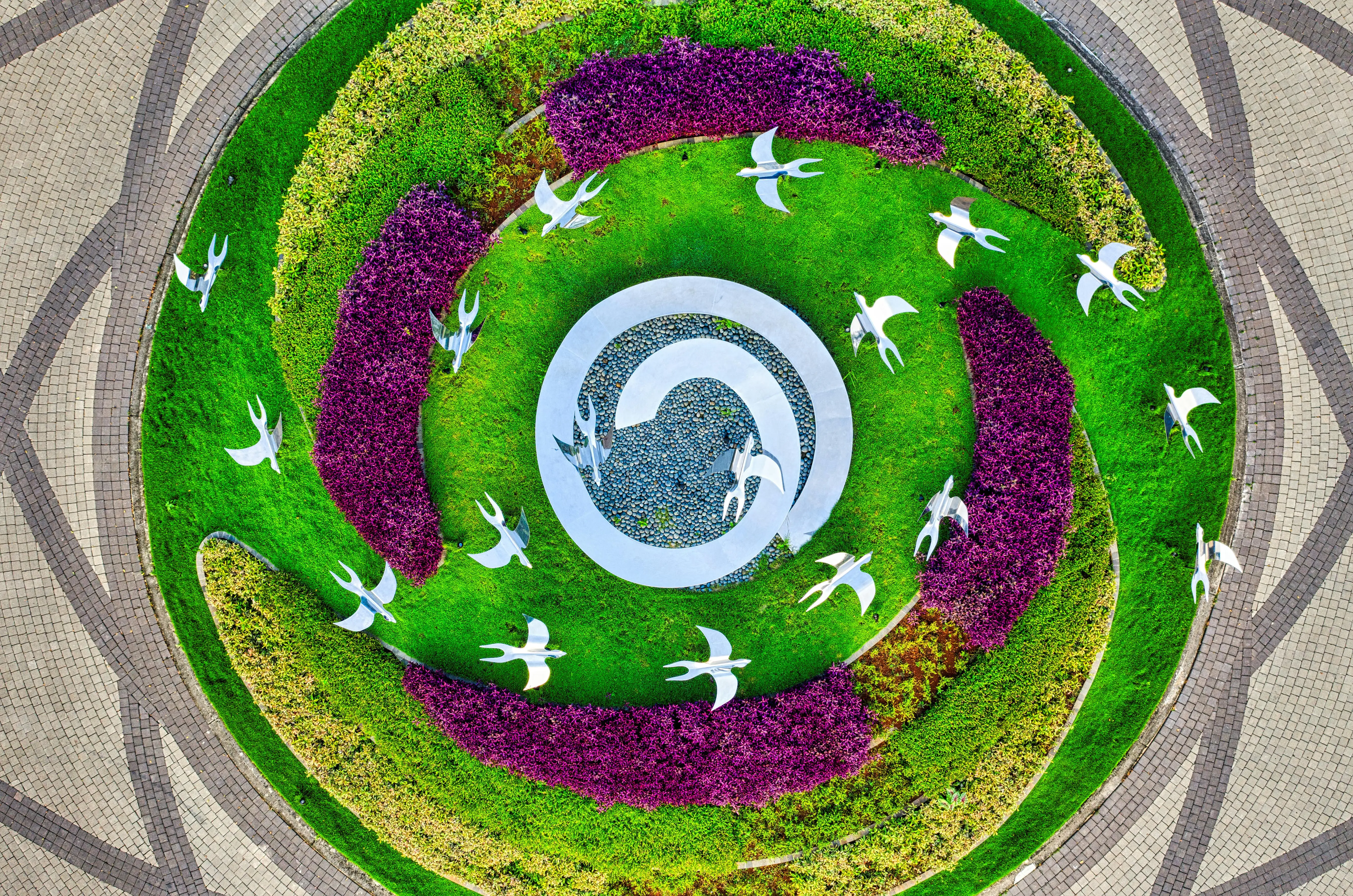 raised circular garden beds Captivating aerial shot of a vibrant garden with artistic bird sculptures in Banten, Indonesia.