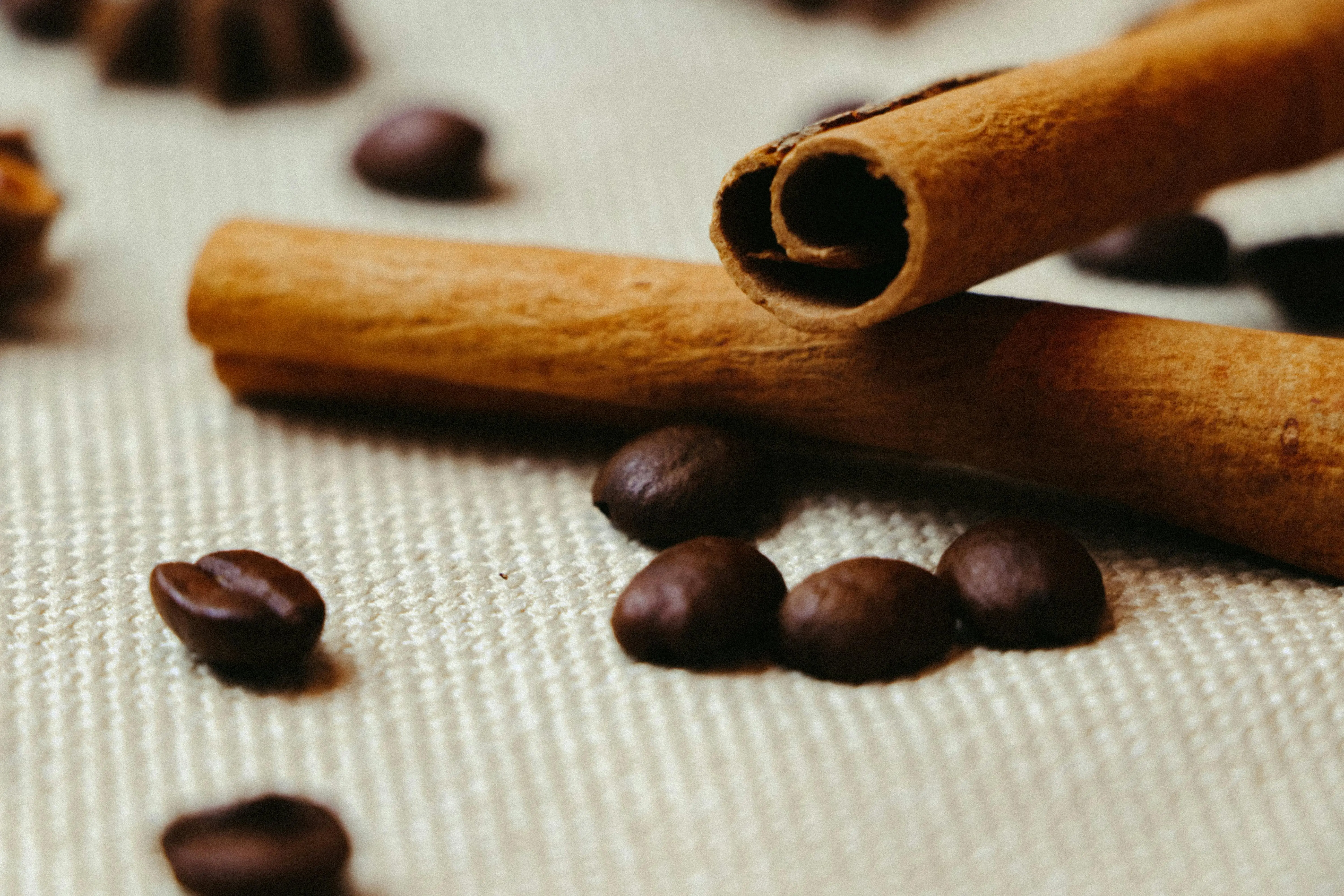 over door spice rack Aromatic cinnamon sticks and coffee beans on a textured surface in warm lighting.