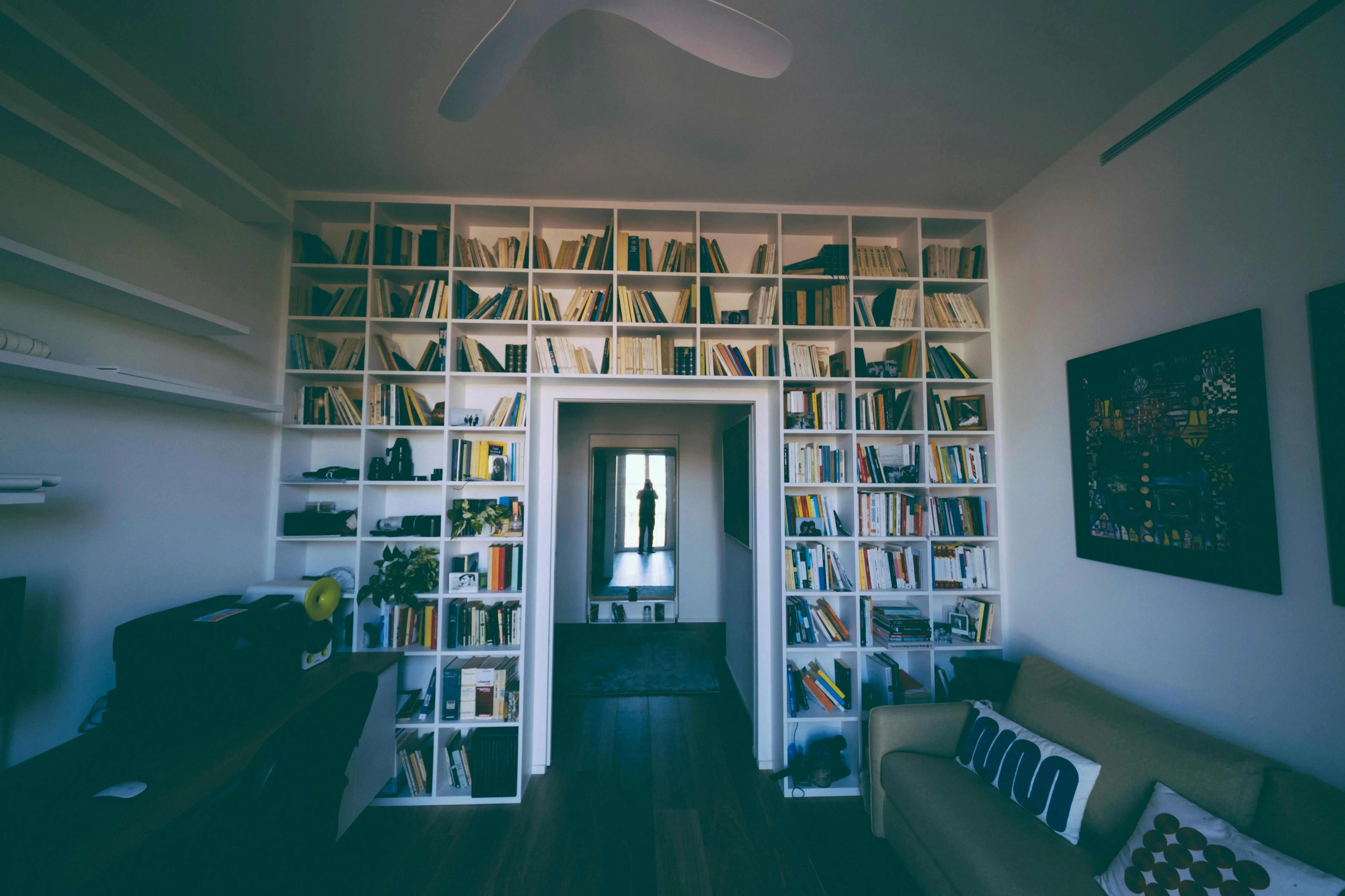 diy small craft room ideas Inviting home library featuring tall bookshelves and cozy seating, perfect for relaxation and reading.
