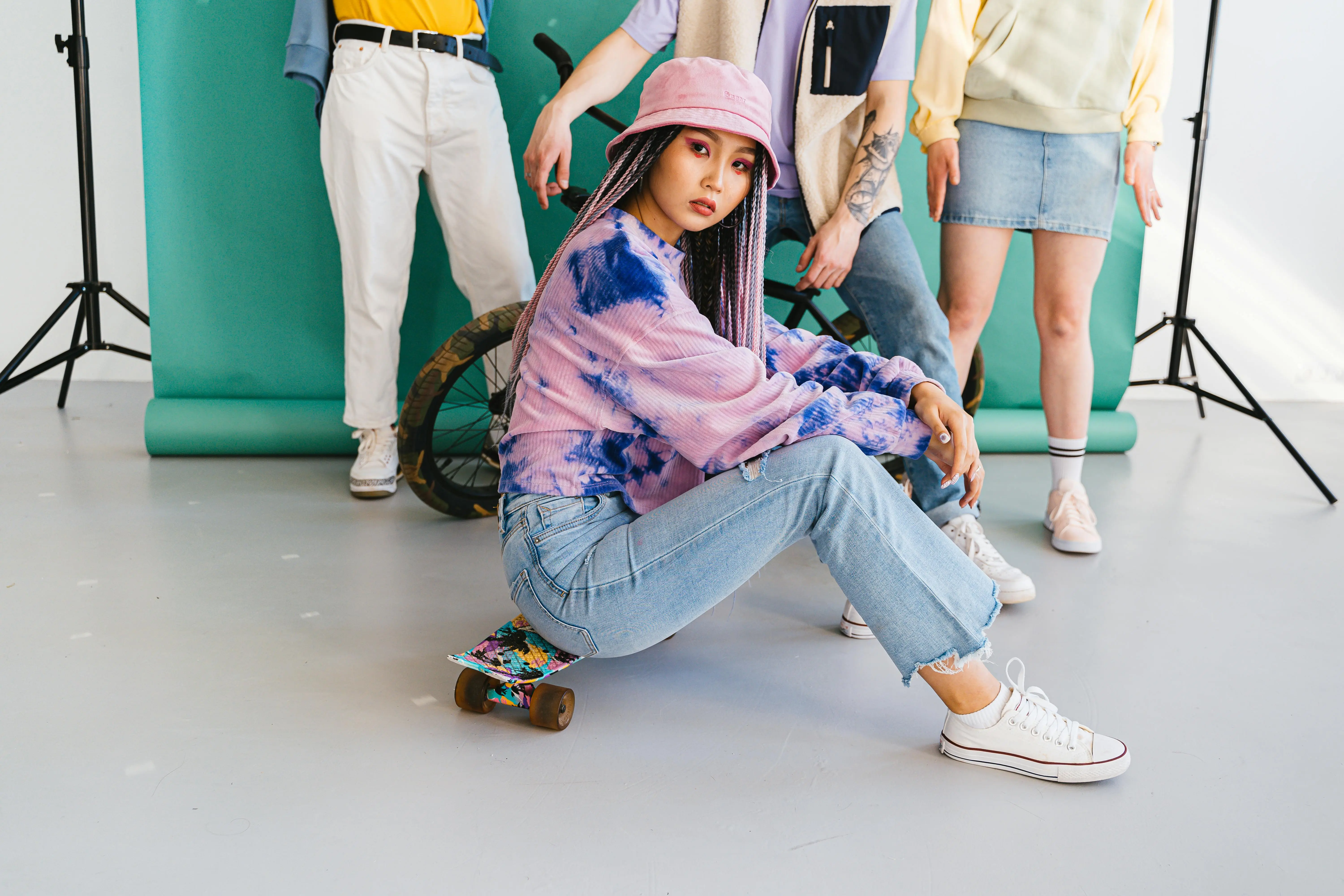 tie dye shirts for men Youthful group in stylish casual wear posing with a skateboard during a modern fashion shoot.