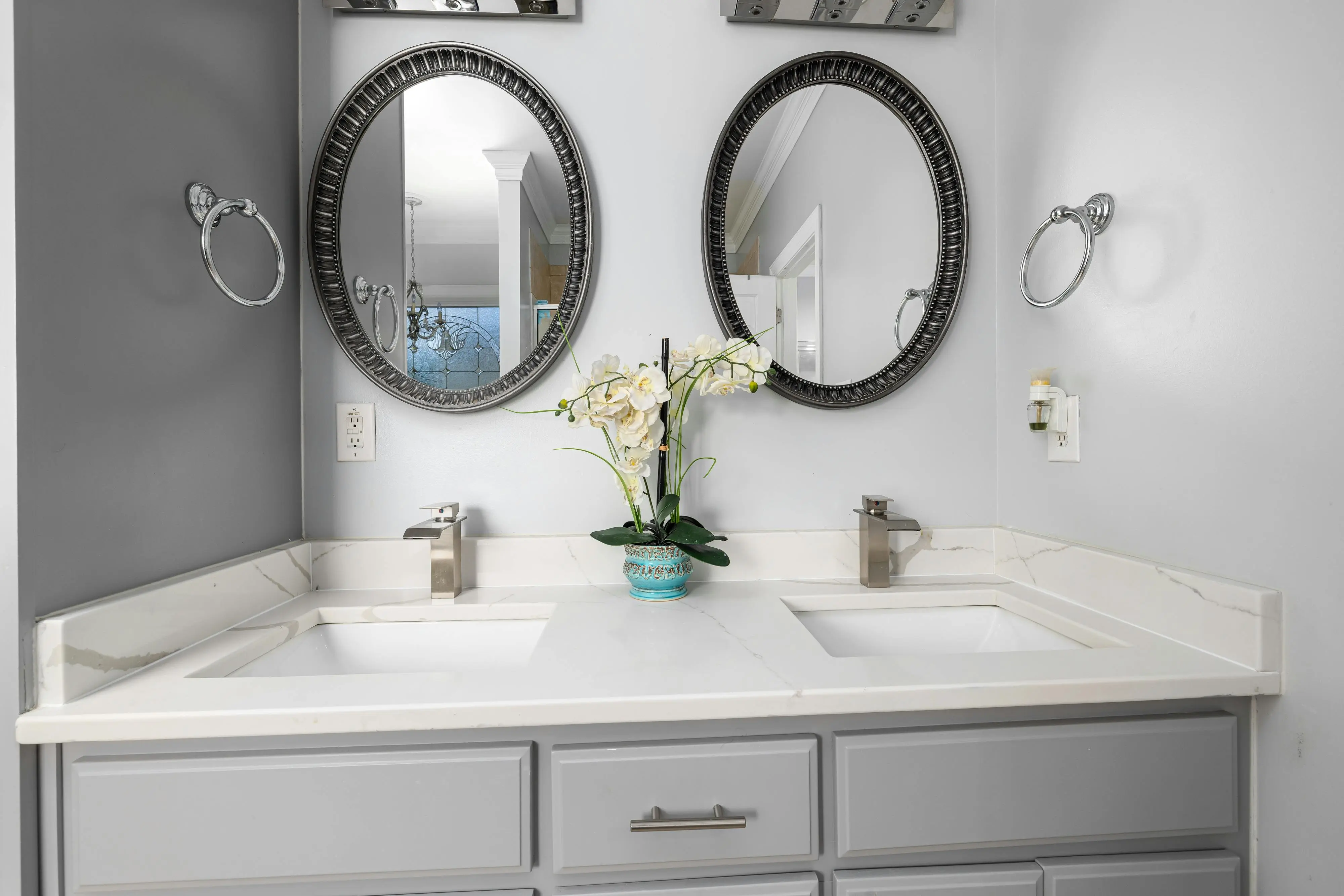 vanity drawer organizer Elegant bathroom with dual sinks, mirrors, and a marble countertop featuring contemporary fixtures.
