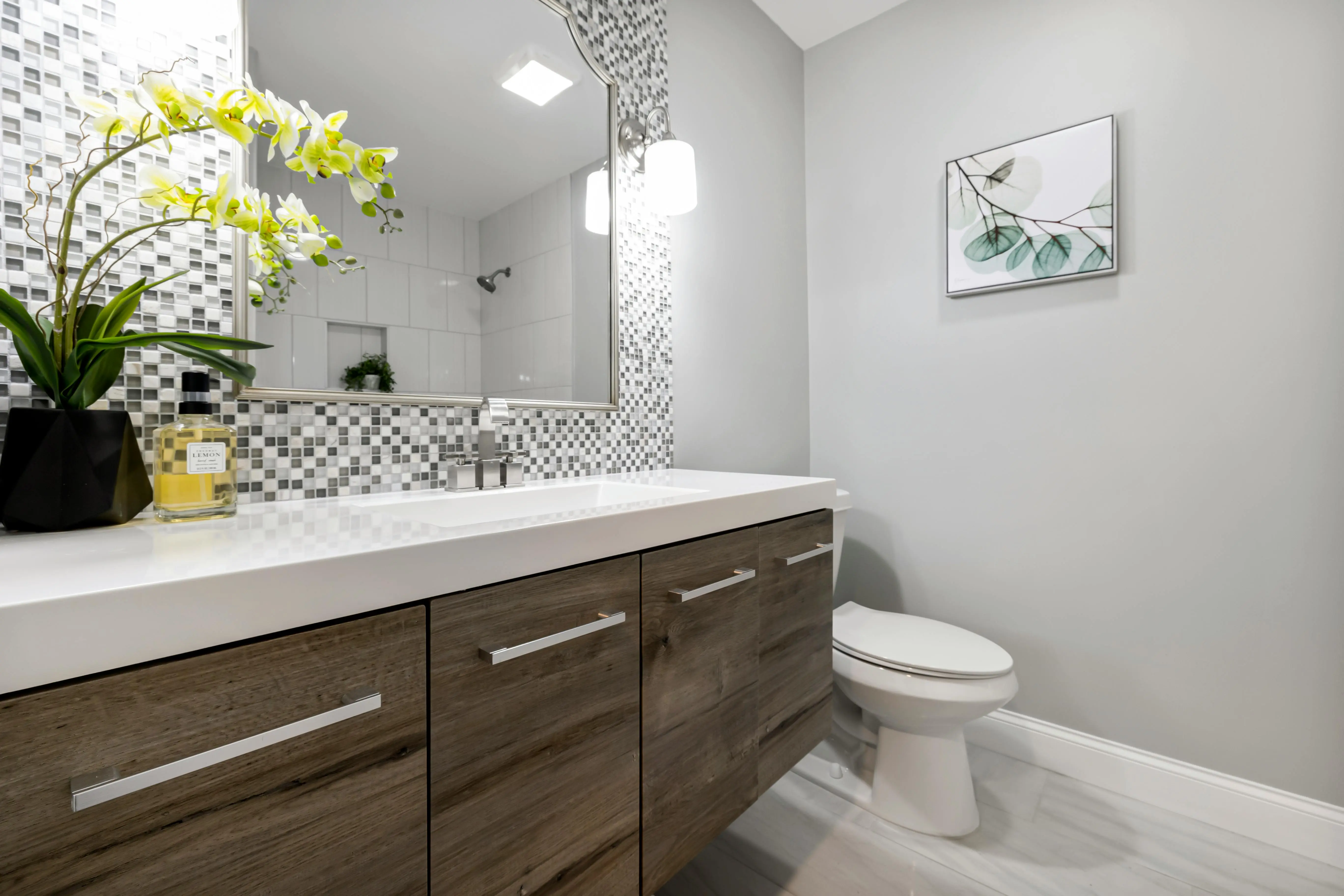 vanity drawer organizer A stylish bathroom interior featuring a modern wooden vanity, decorative tiles, and indoor plants.