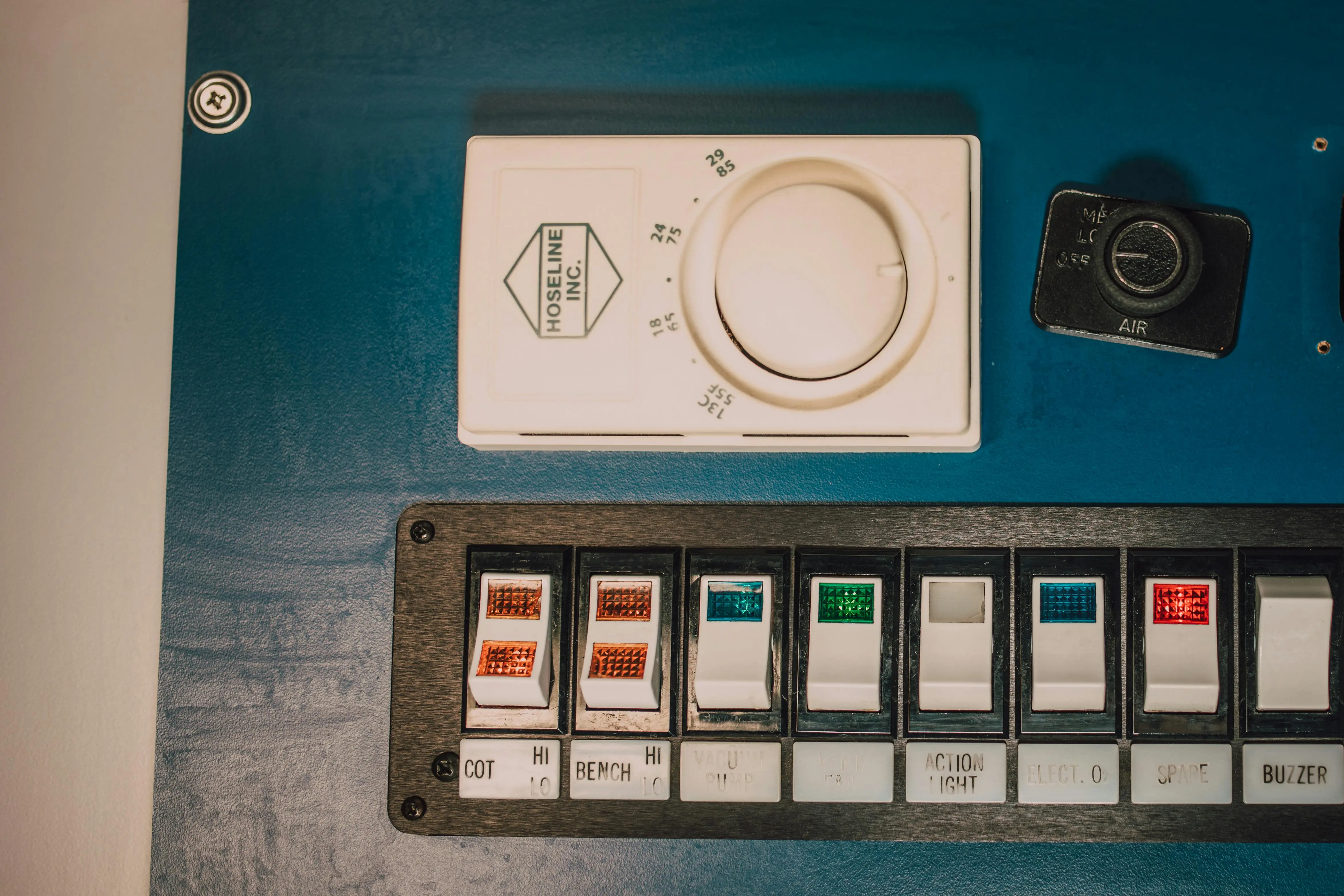 industrial washing machine Close-up of a control panel with switches and a dial, ideal for industrial themes.