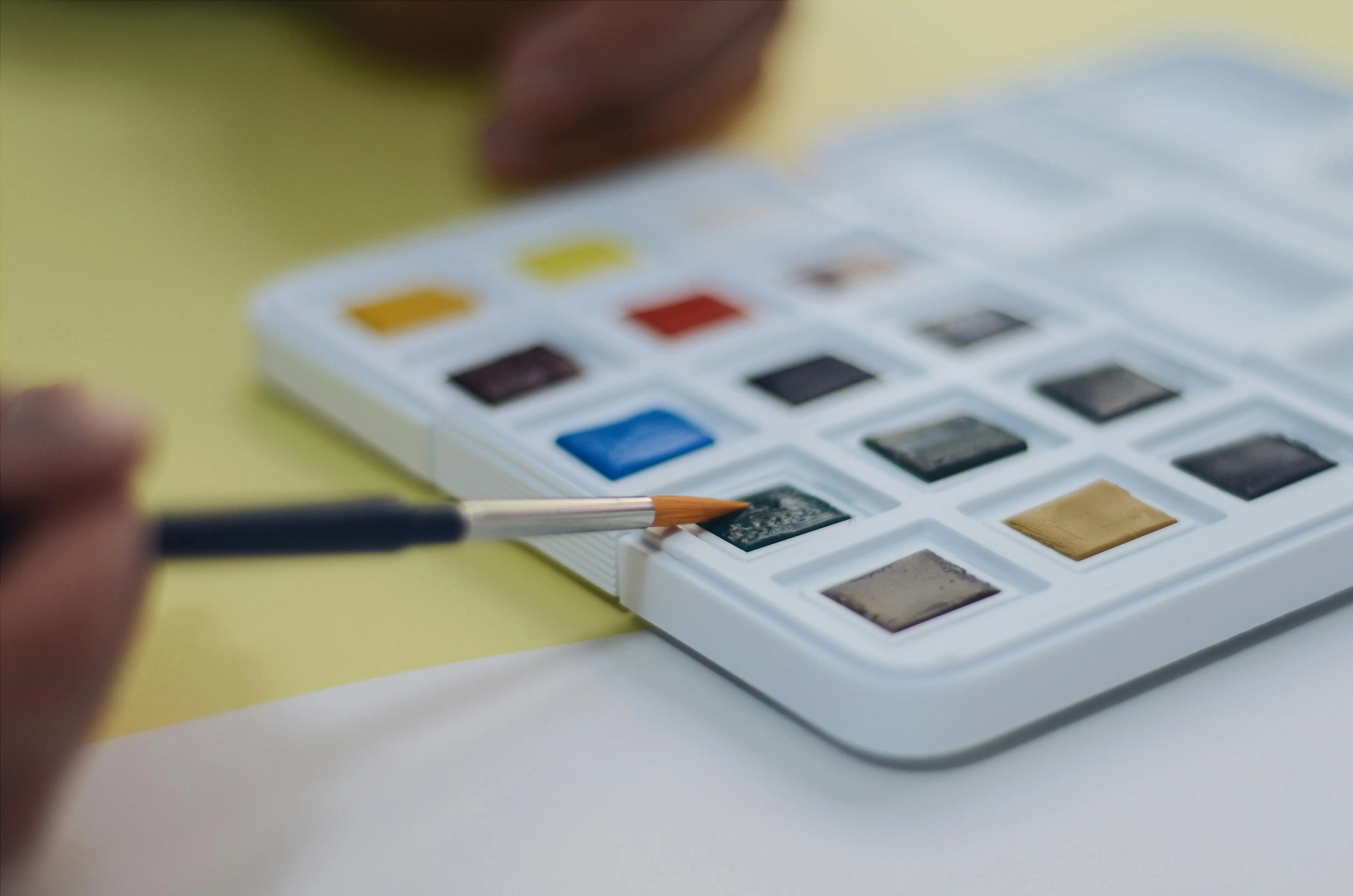 watercolour painting kit Close-up of watercolor paints and brush in an art studio setting, perfect for creative projects.