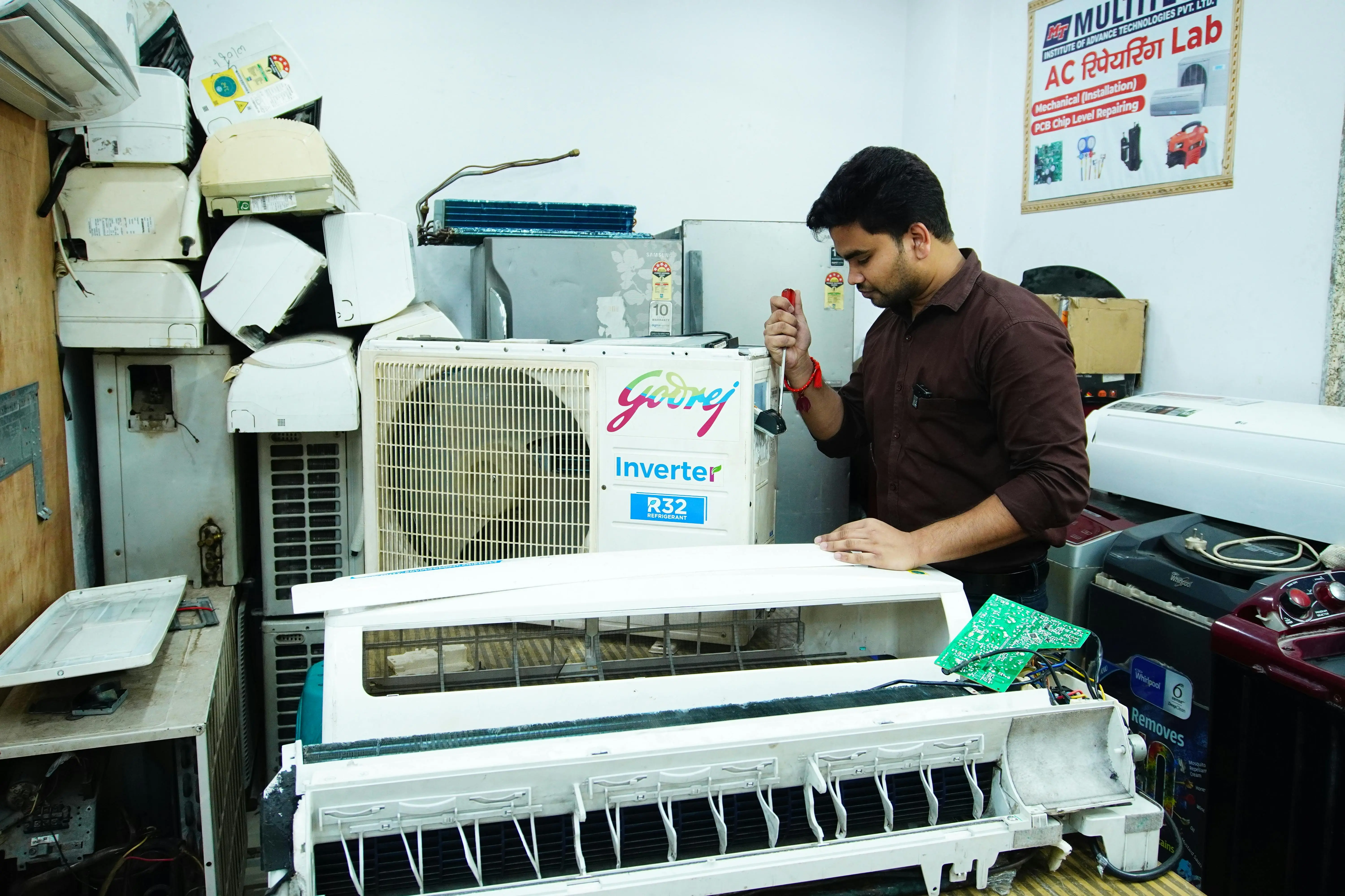 how to clean evaporator coil Technician repairing an air conditioner unit in New Delhi workshop.
