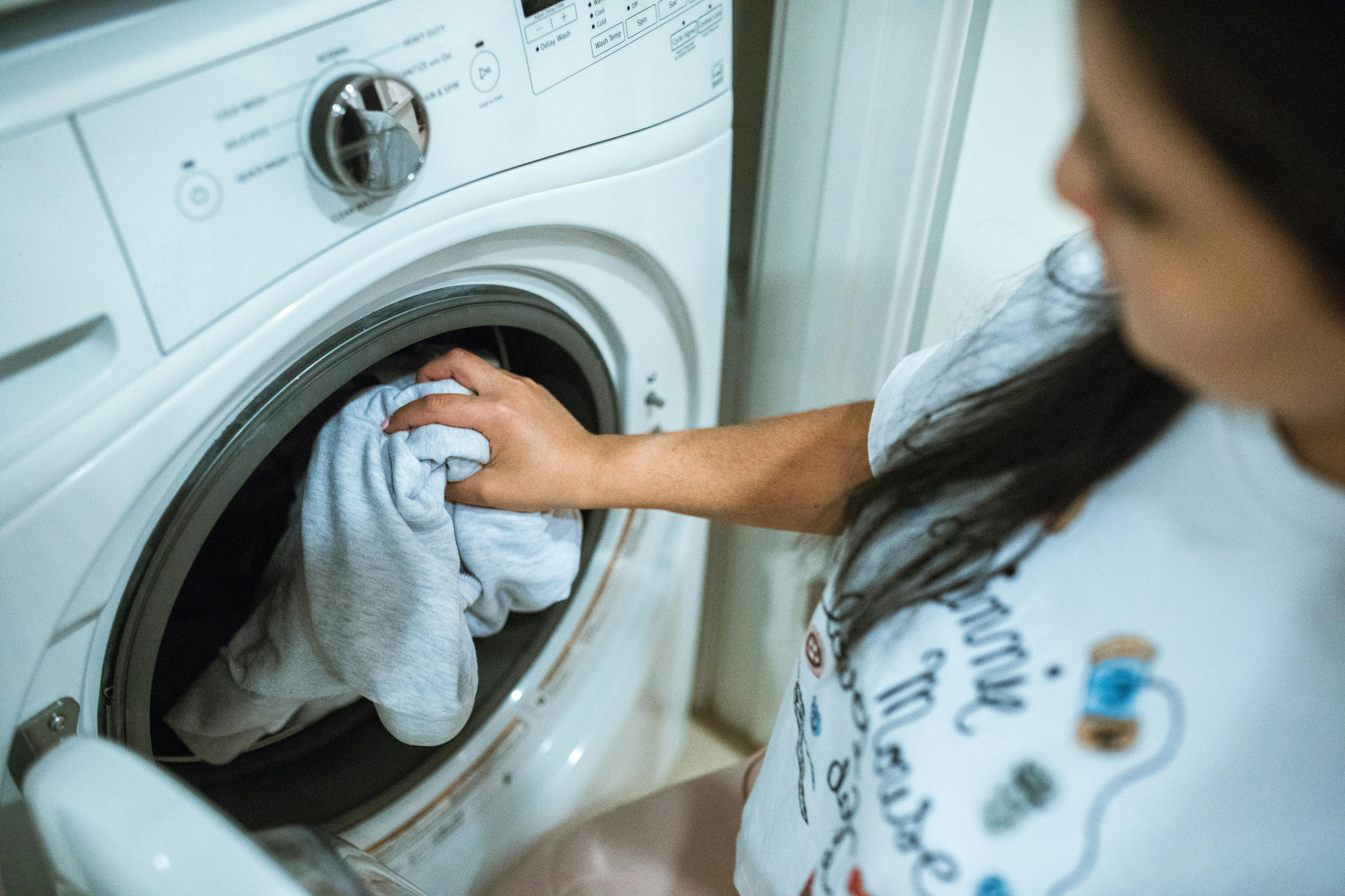 rv with washer and dryer A woman loading laundry into a washing machine indoors, focusing on household chores.