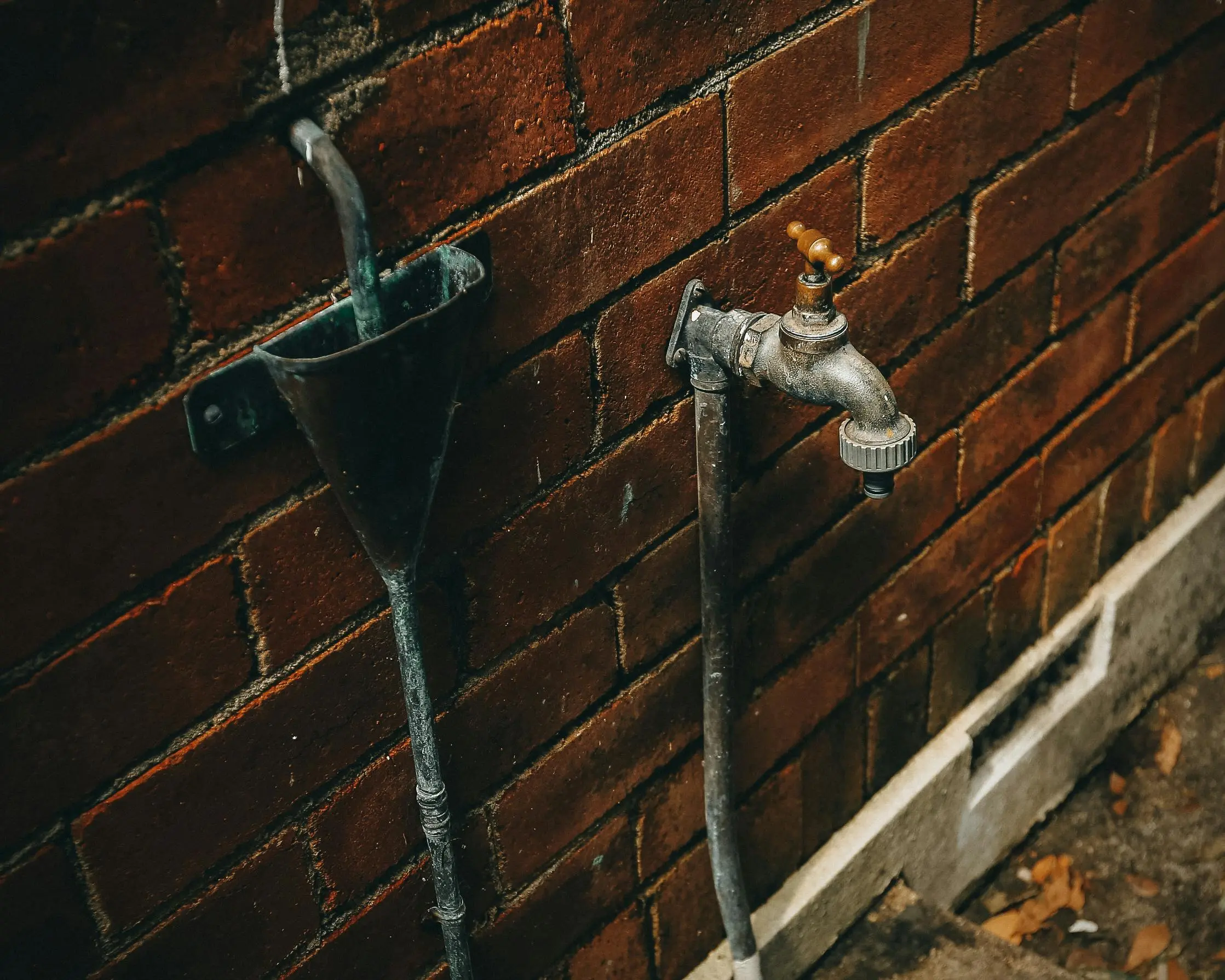 rv with washer and dryer Close-up of a rusty outdoor faucet attached to a weathered brick wall.