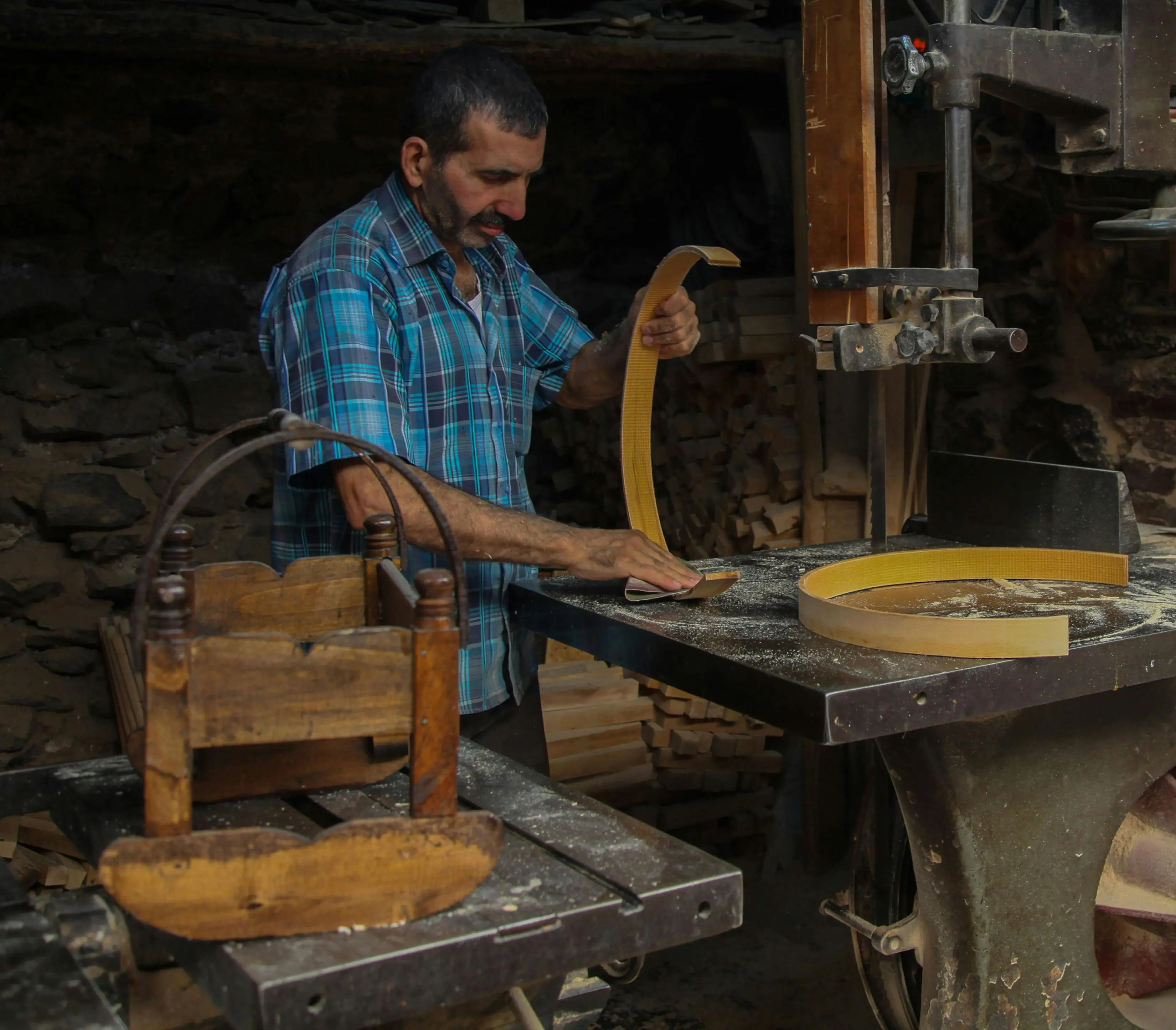 carpenter with tools Experienced artisan sanding wooden pieces in a traditional workshop setting.