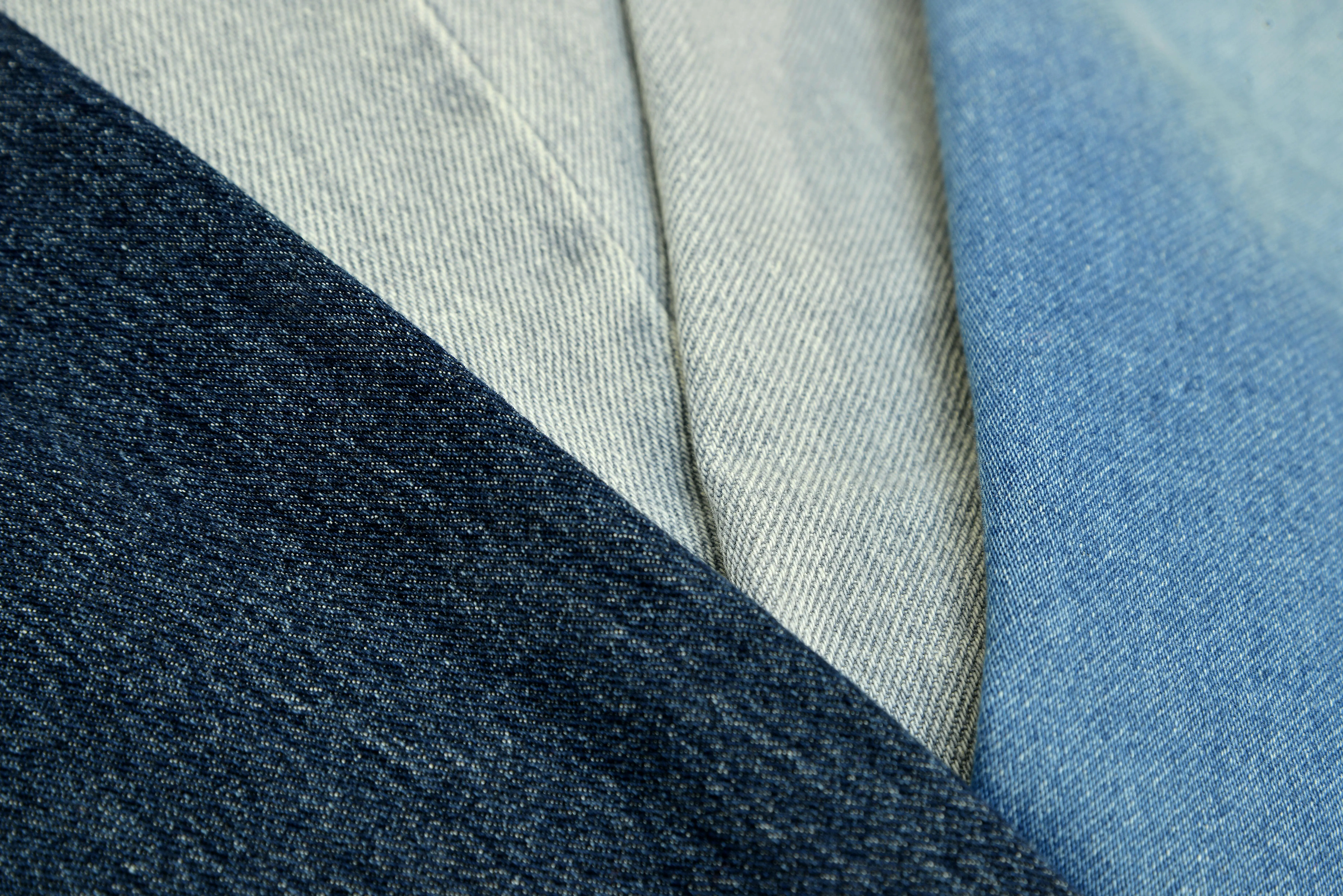 how to get grass stains out of jeans Detailed shot of blue denim fabric showcasing different textures and shades, ideal for fashion design and textile background.