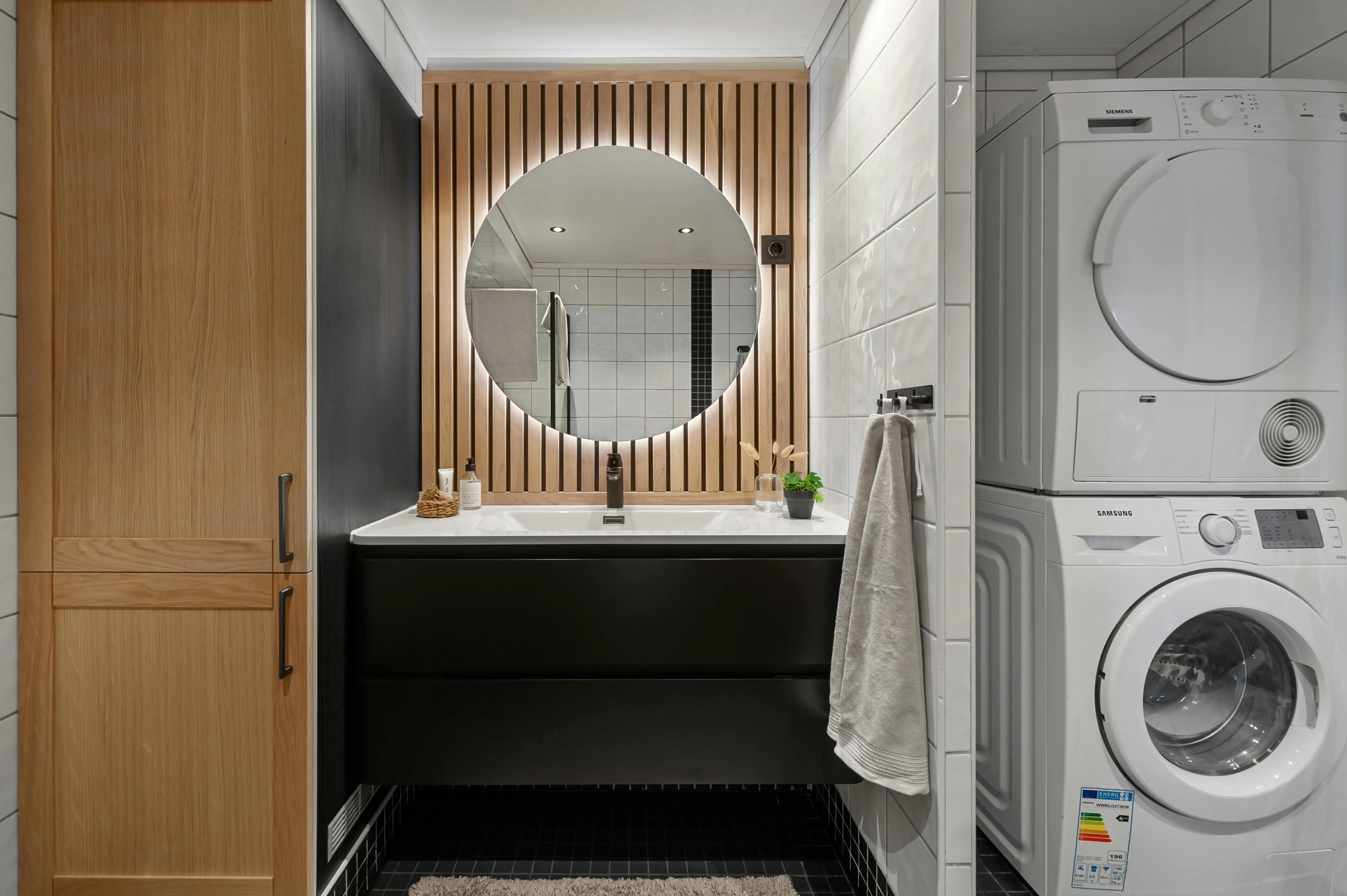 rv with washer and dryer Sleek bathroom featuring a round mirror, modern sink, and integrated washer and dryer.