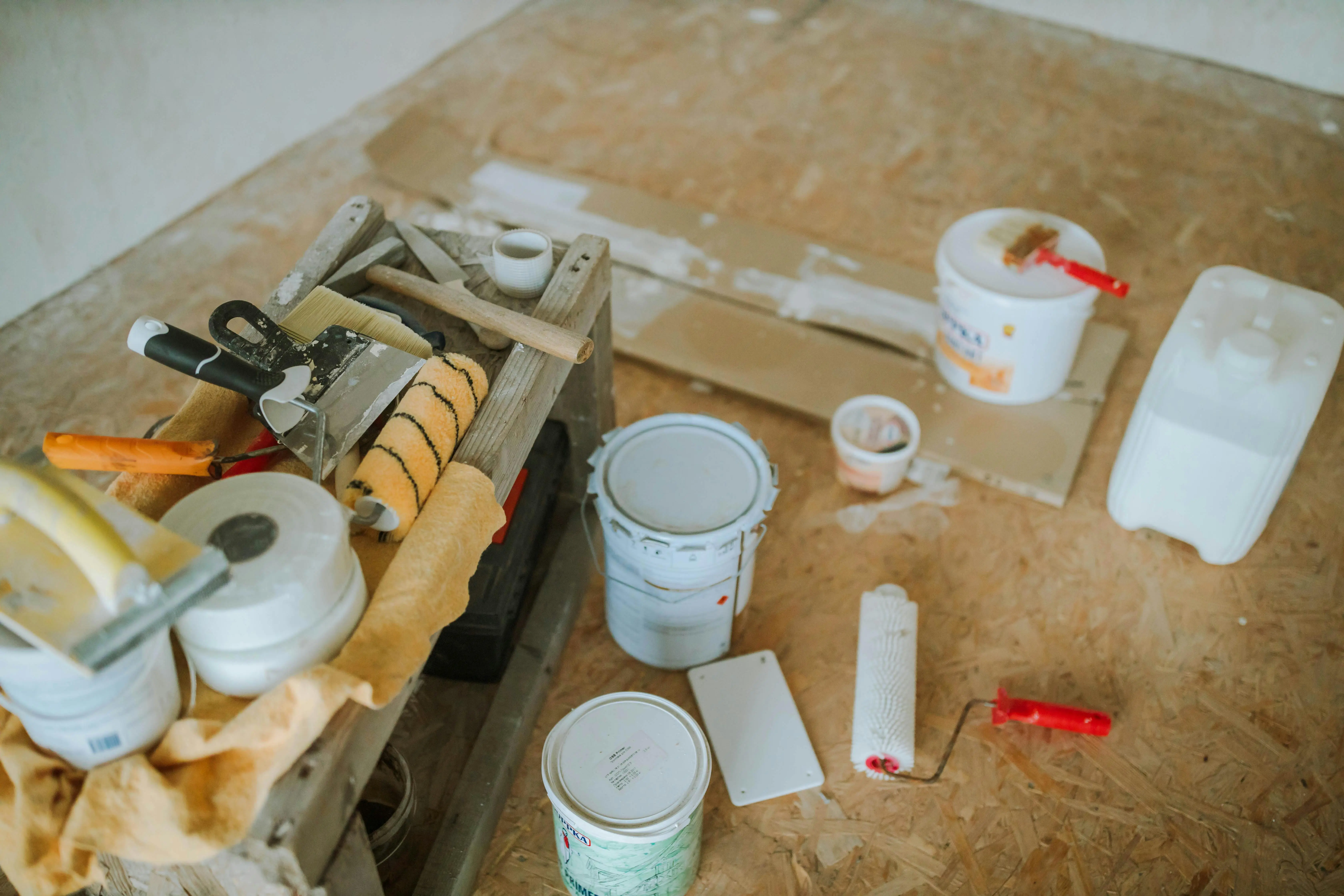 diy wood floor refinishing Overhead shot of tools and paint supplies for a home renovation project.