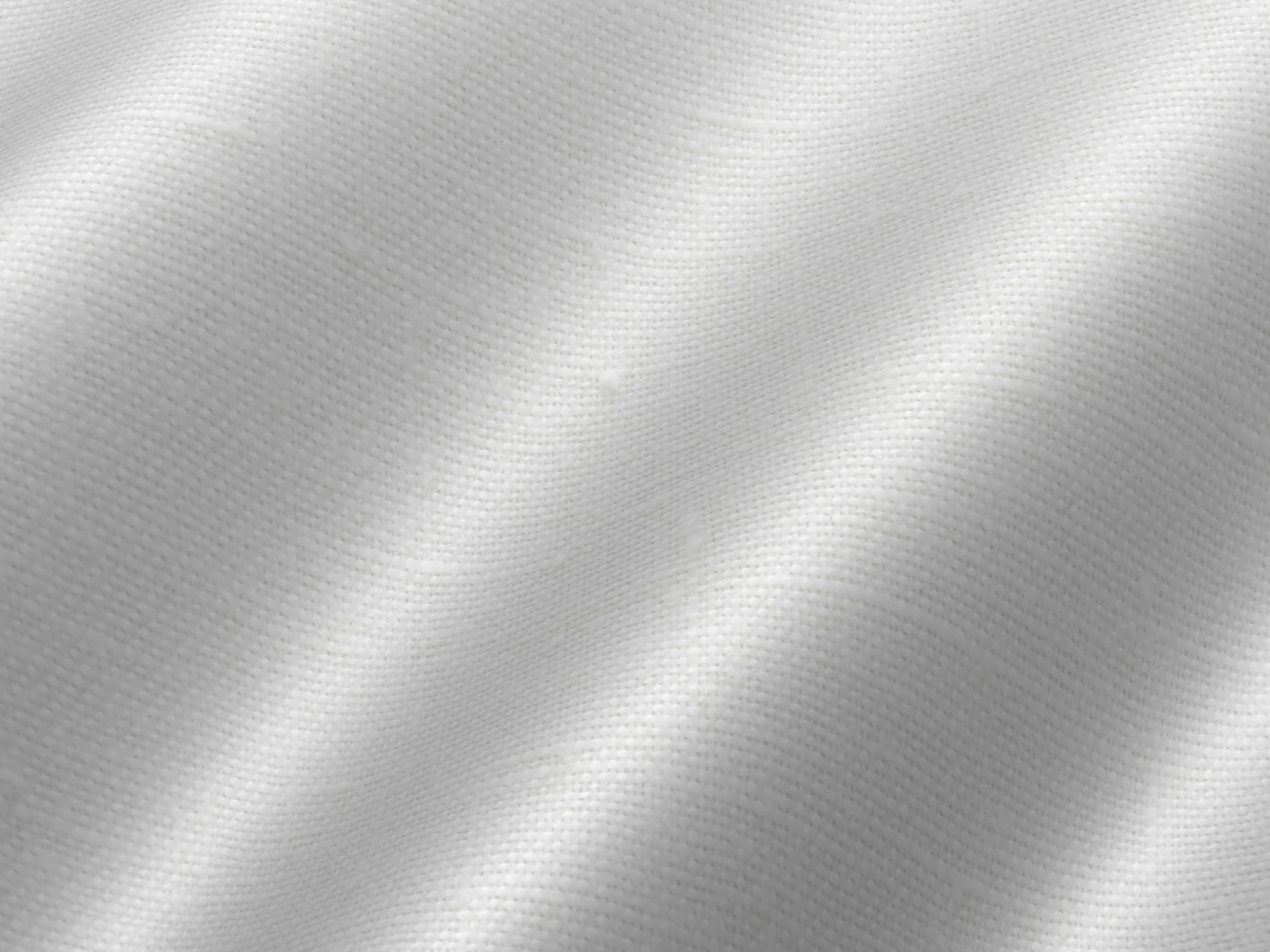 how to get period blood out of clothes Close-up of white fabric showcasing its smooth texture and subtle waves.