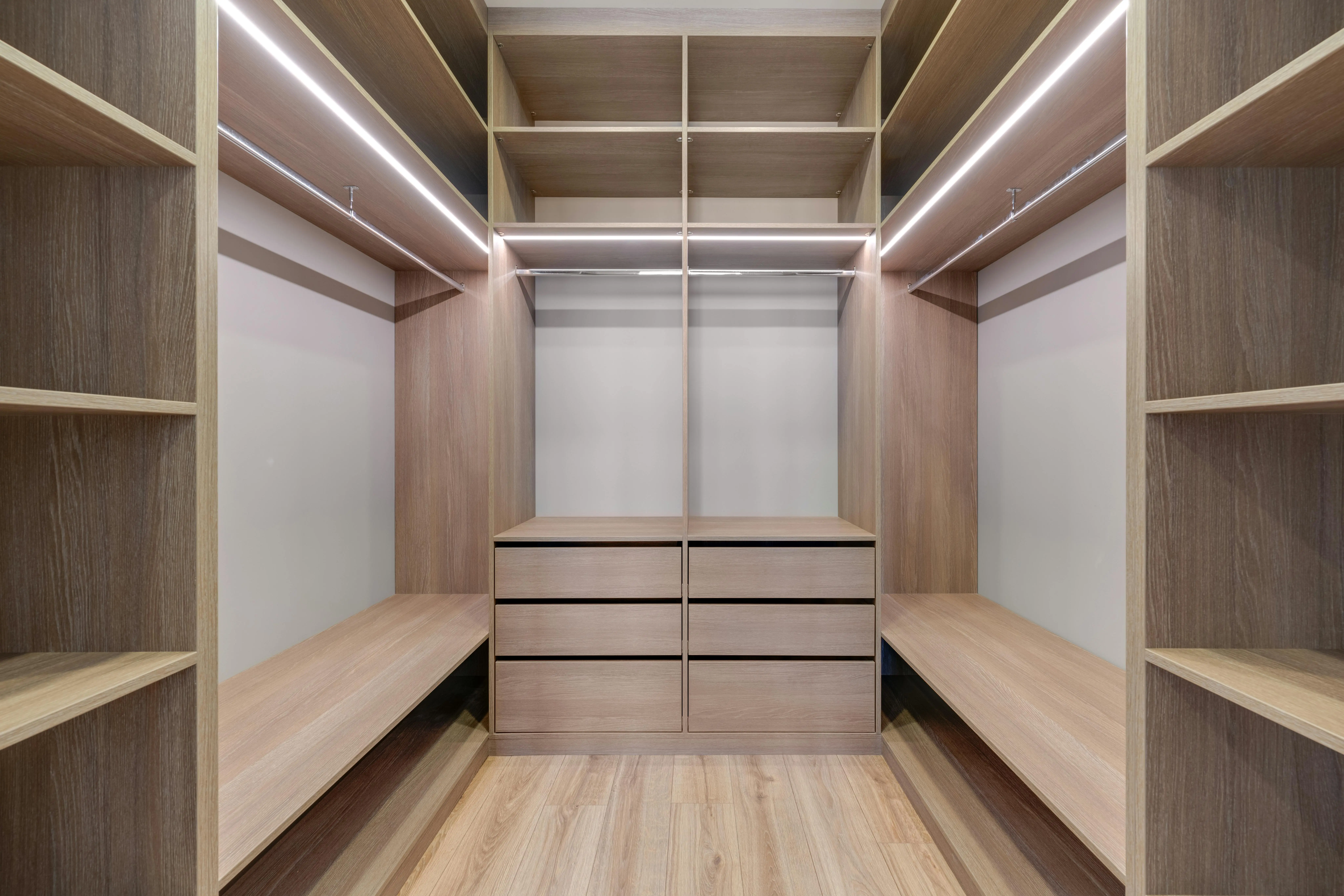 closetmaid shelving Spacious walk-in closet with wooden shelves and LED lighting creates a minimalist and modern design.