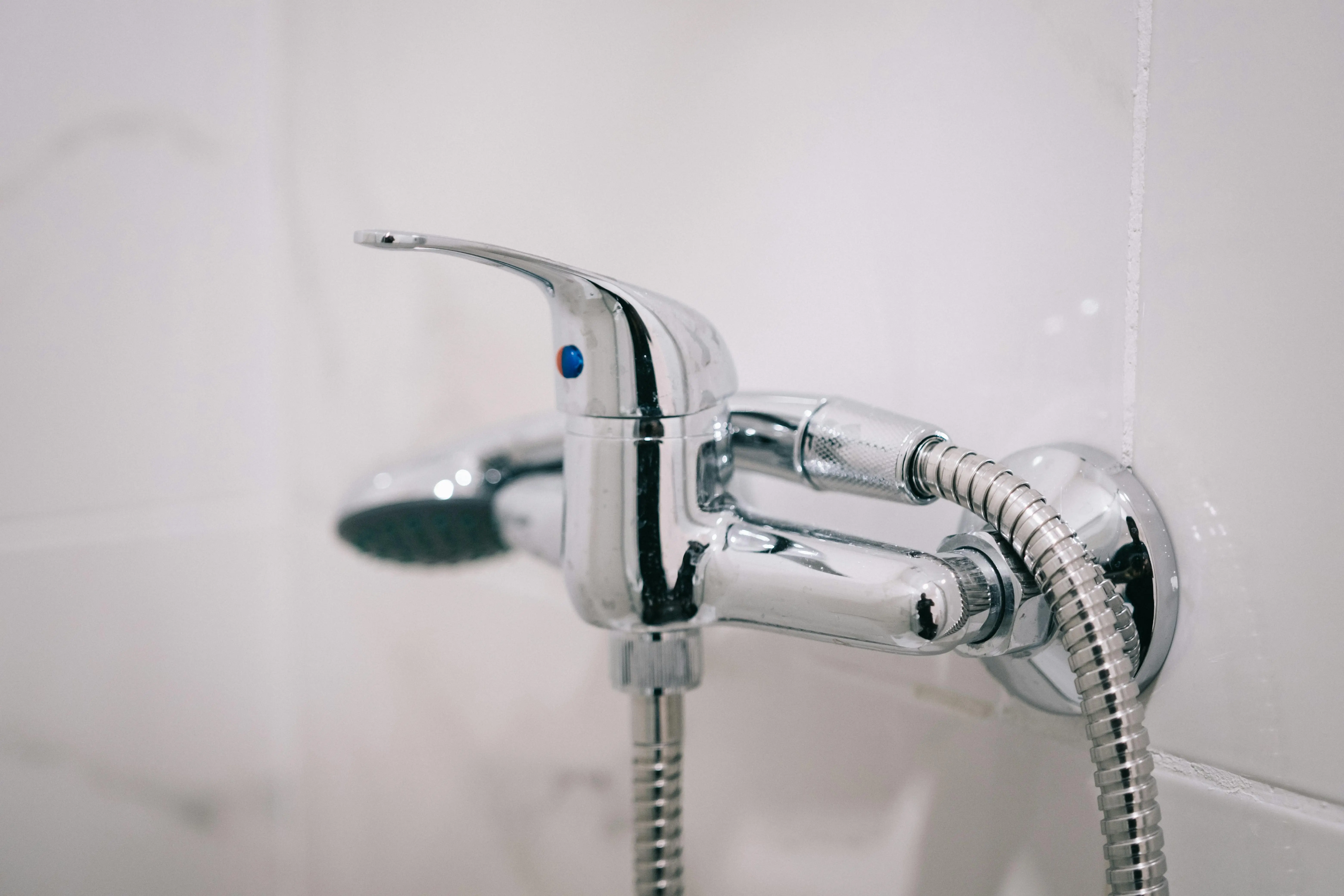 cost to replace shower valve A detailed view of a sleek chrome shower faucet in a clean bathroom setting.