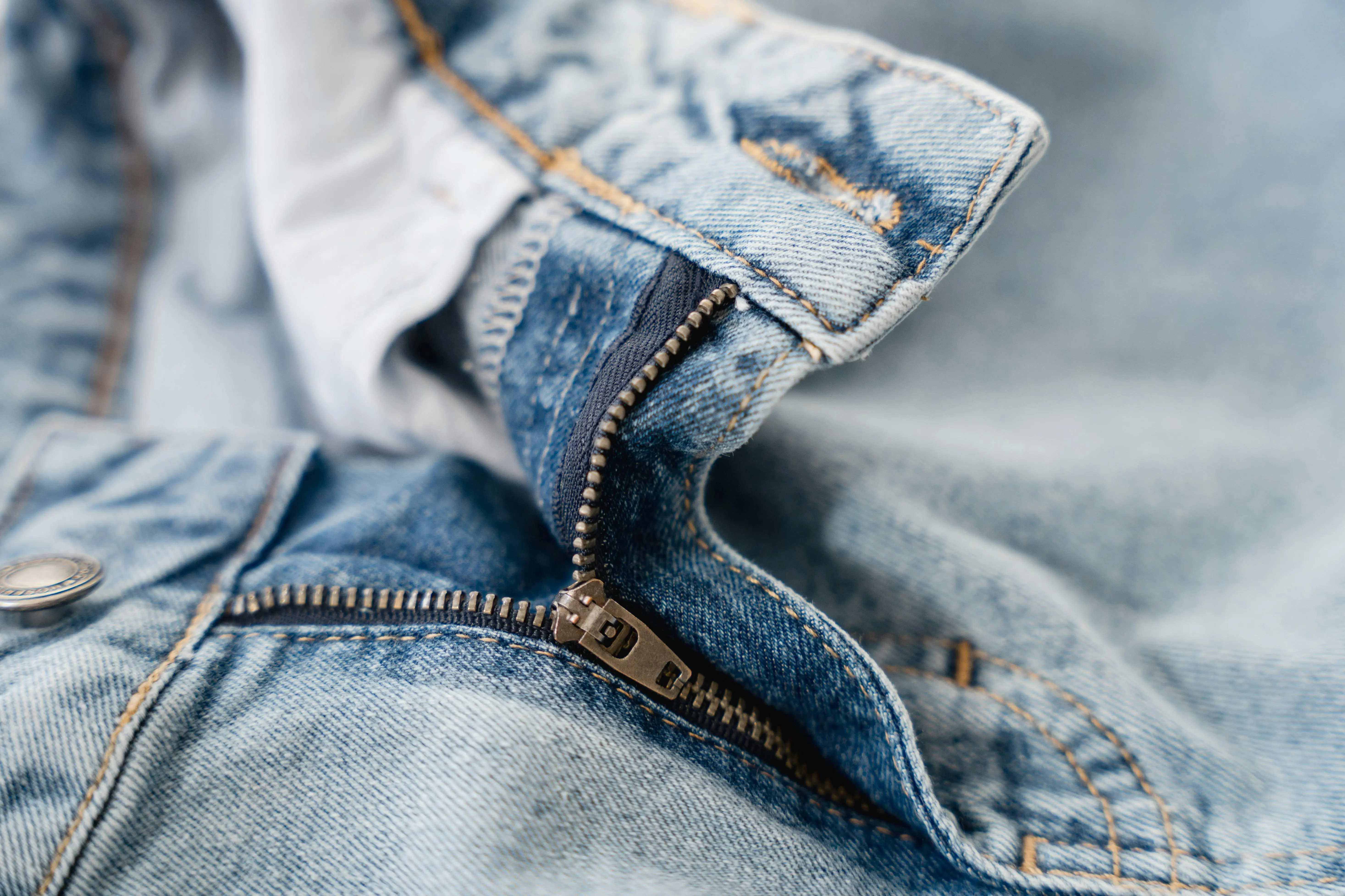 how to get grass stains out of jeans Detailed shot of a blue denim jeans zipper showcasing fashion texture and stitching.