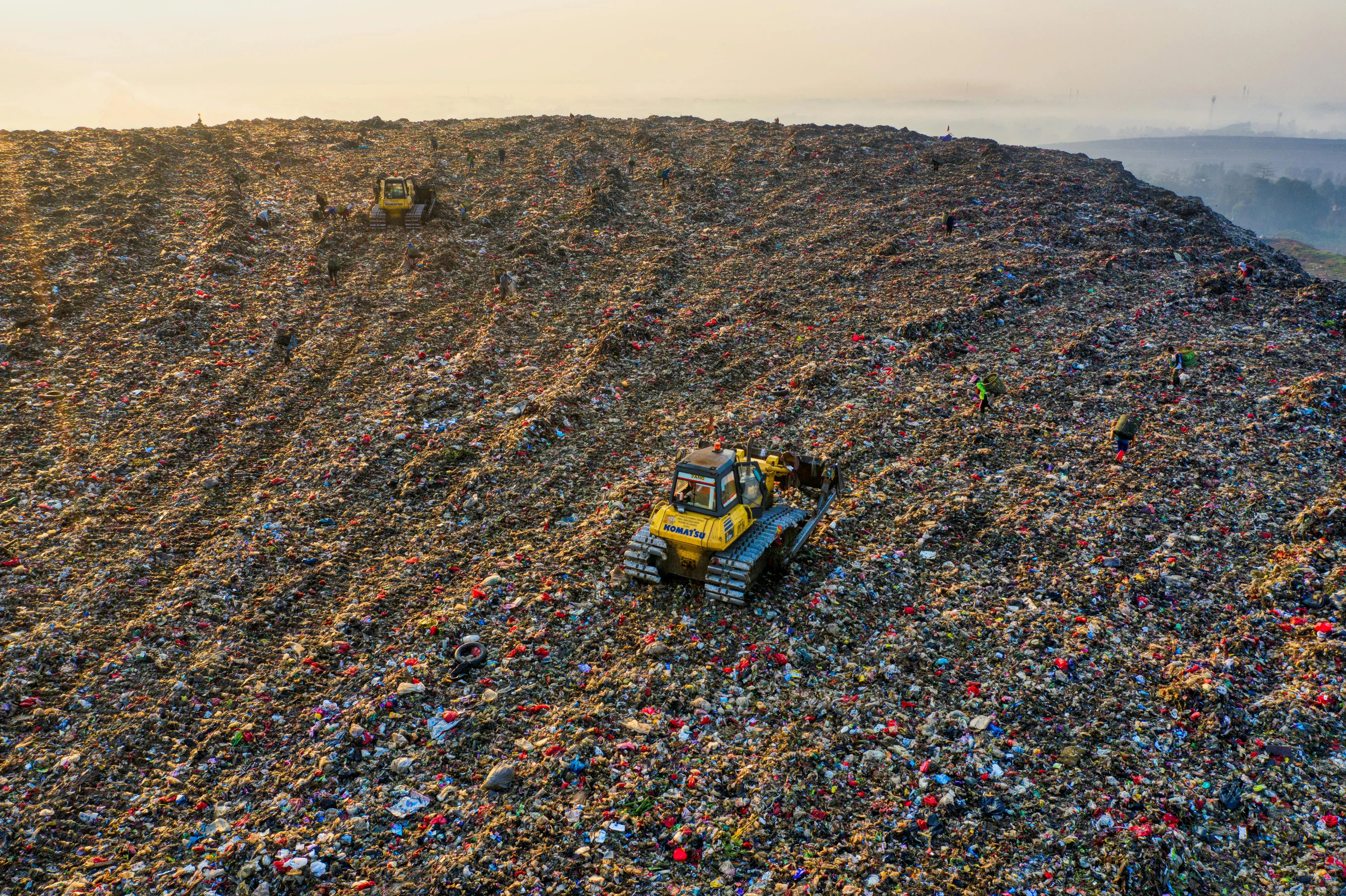 and paper towels Drone shot capturing environmental impact at a landfill in West Java with visible machinery.