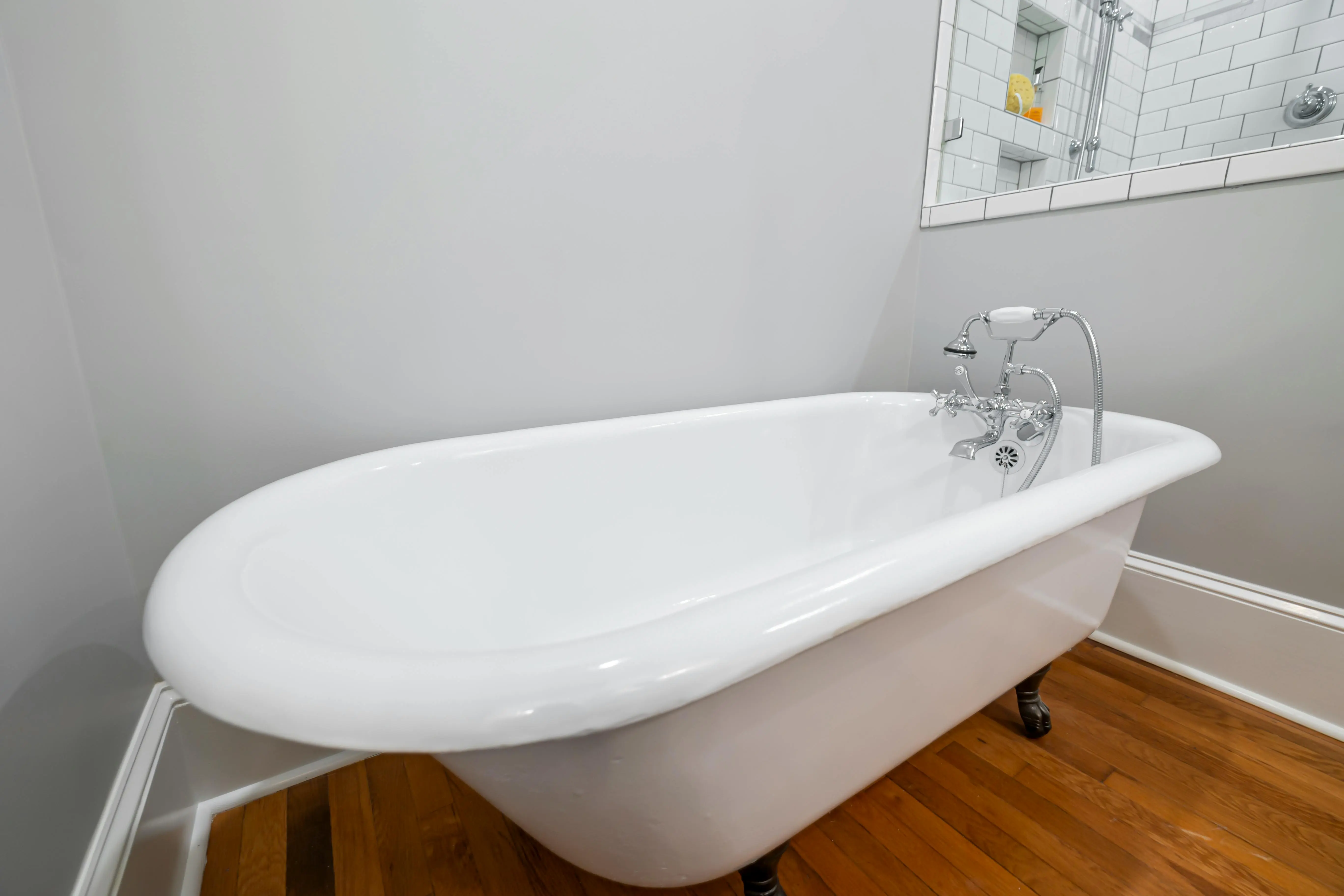 crack in bathtub Stylish vintage bathtub with chrome faucet and wooden floor in a modern bathroom.