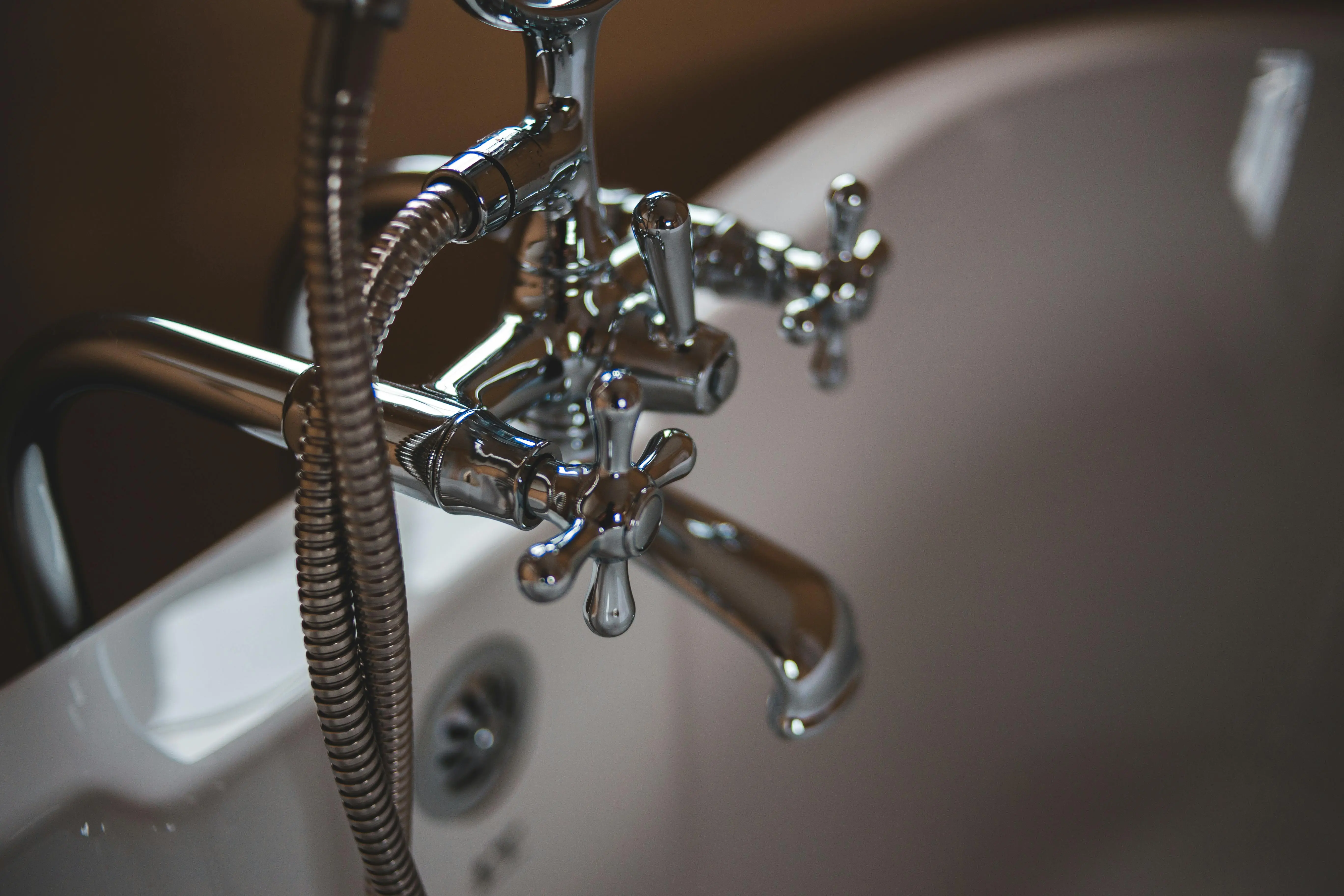 cost to replace shower valve Elegant close-up of a shiny chrome faucet in a modern bathroom setting.