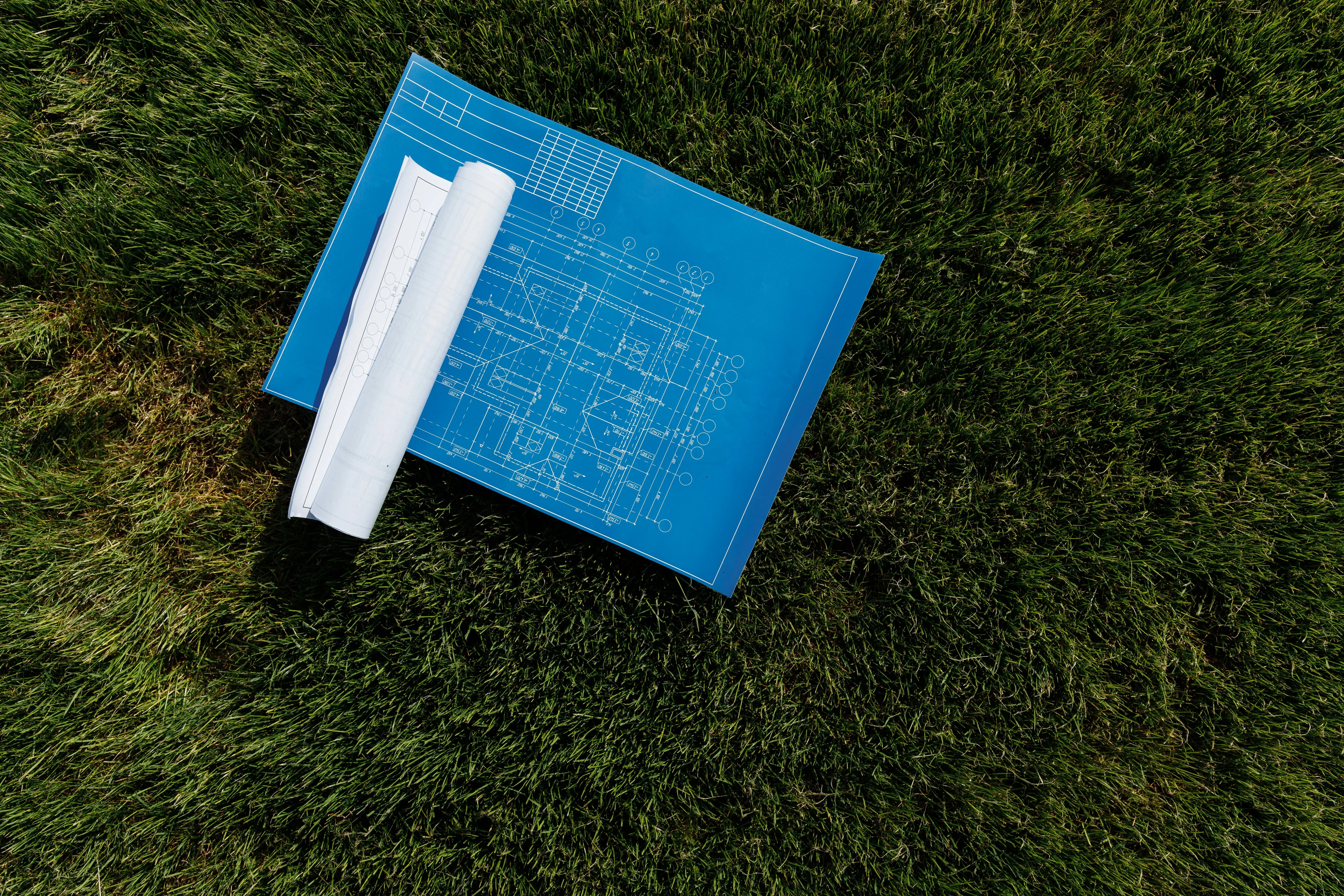 soil probe Top view of architectural blueprints on a grassy field, ideal for construction themes.