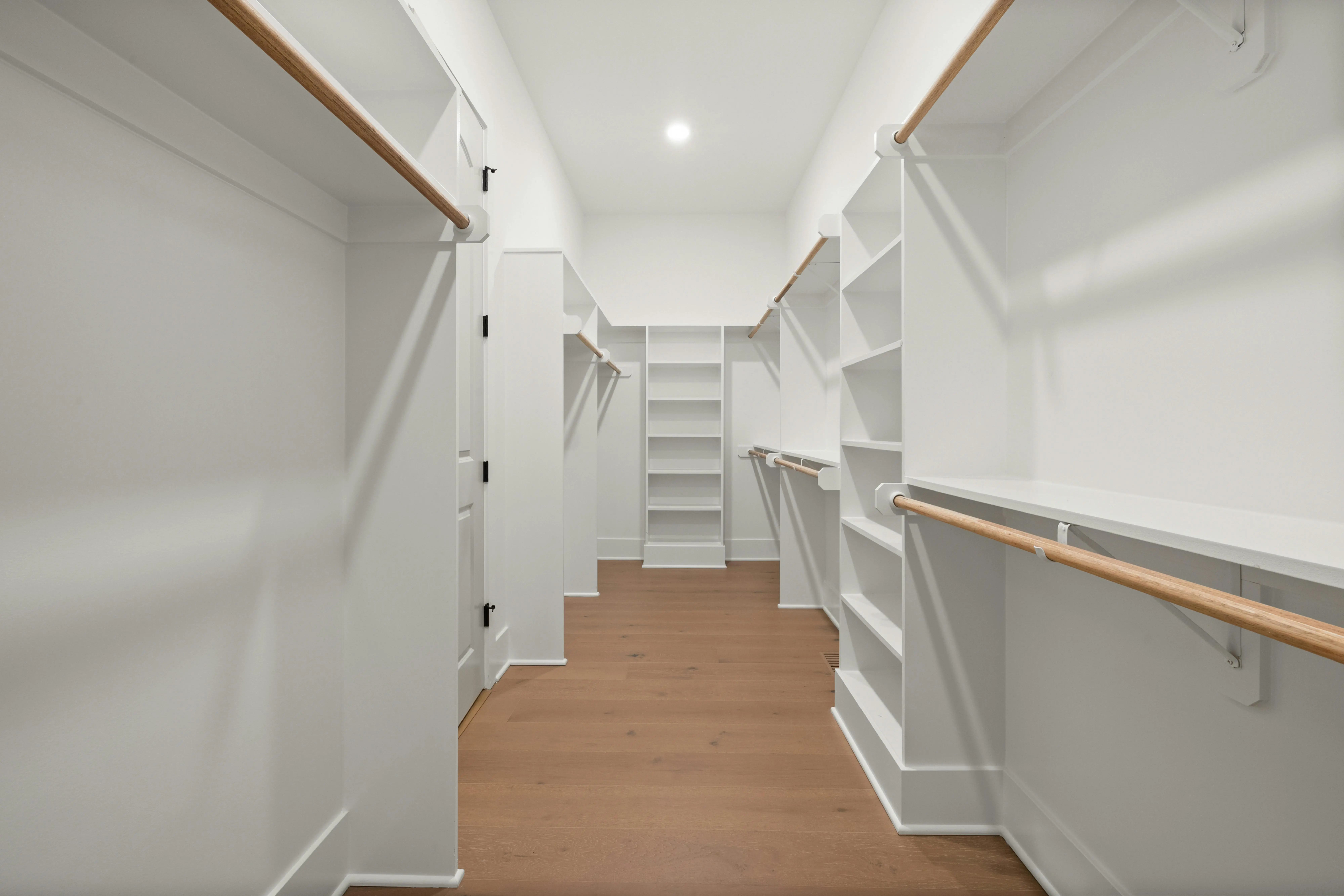 closetmaid shelving Modern walk-in closet with wooden floors and white shelving units.