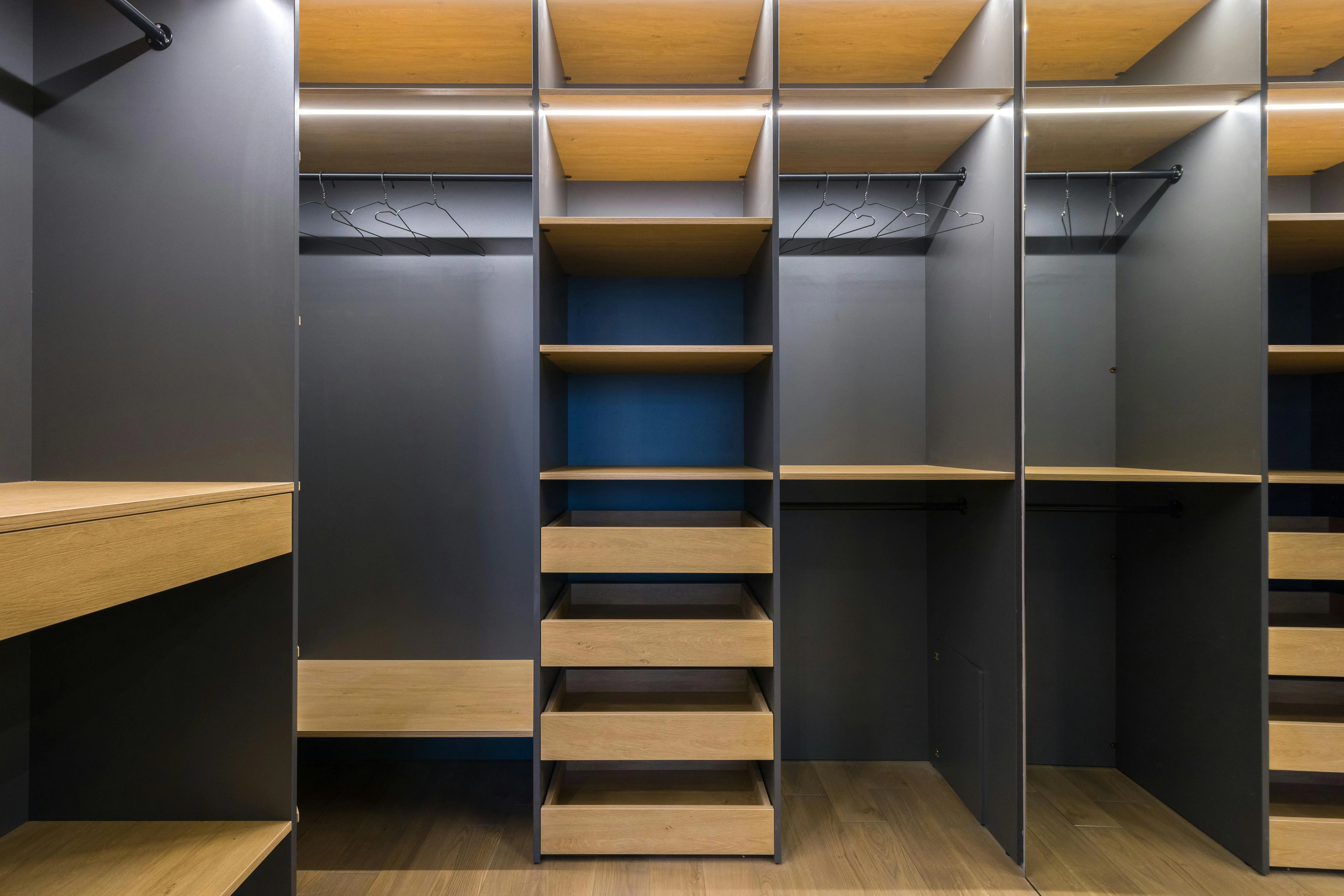 closetmaid shelving Spacious modern walk-in closet featuring wooden shelving and a sleek design, ideal for organization.