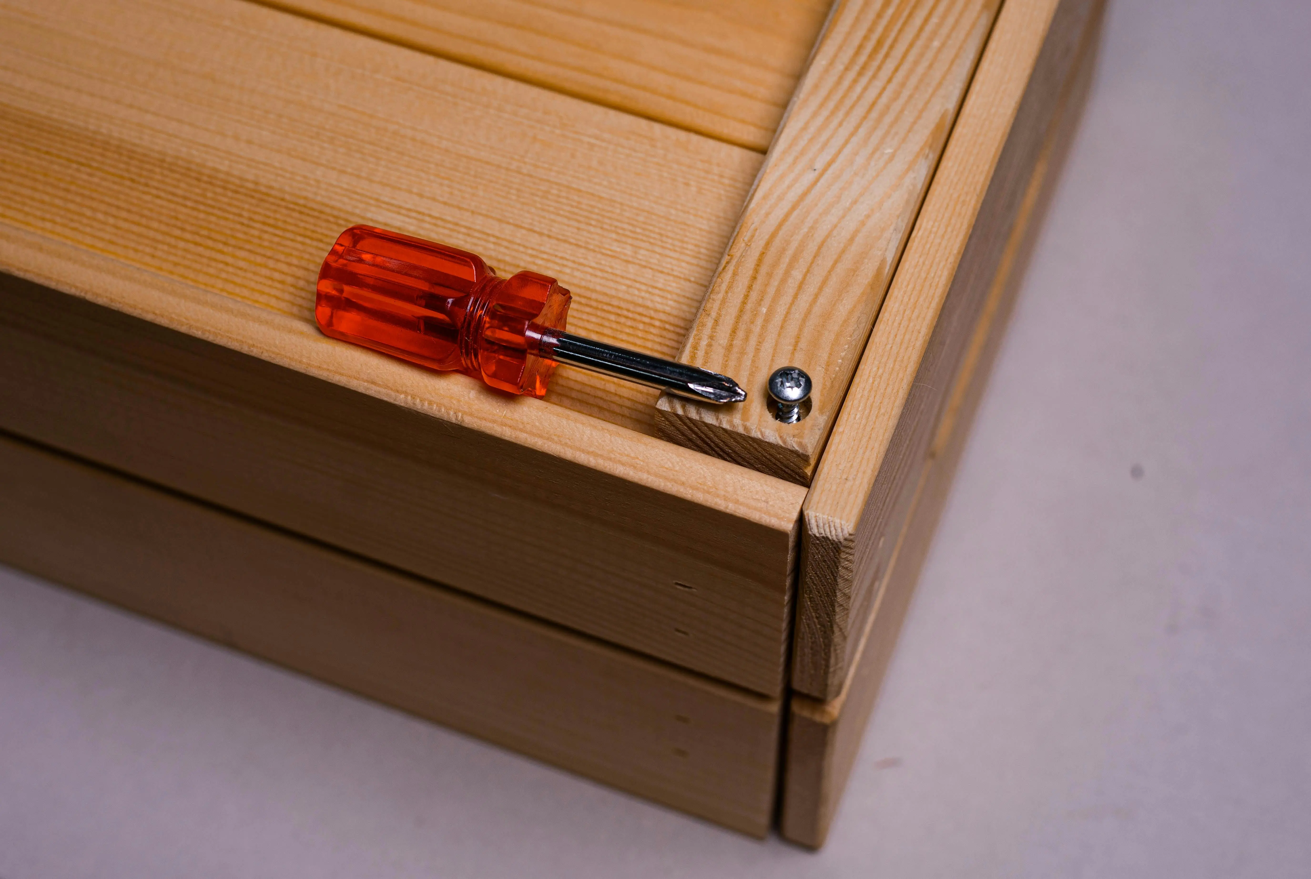 carpenter with tools Detailed shot of a screwdriver and screw on wood, showcasing tool precision.