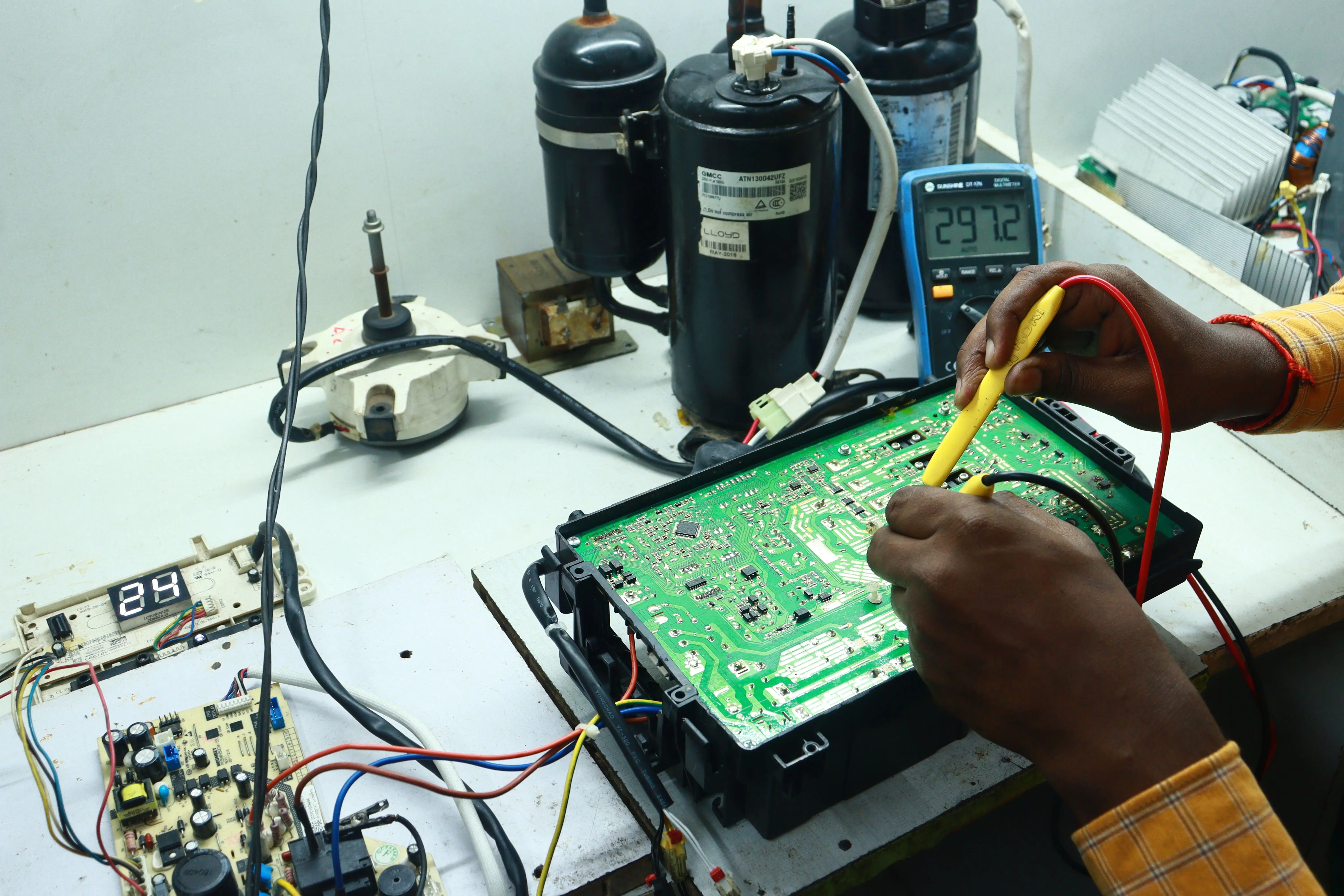 ac stopped working Technician working on AC PCB with tools and equipment, captured in New Delhi workshop.