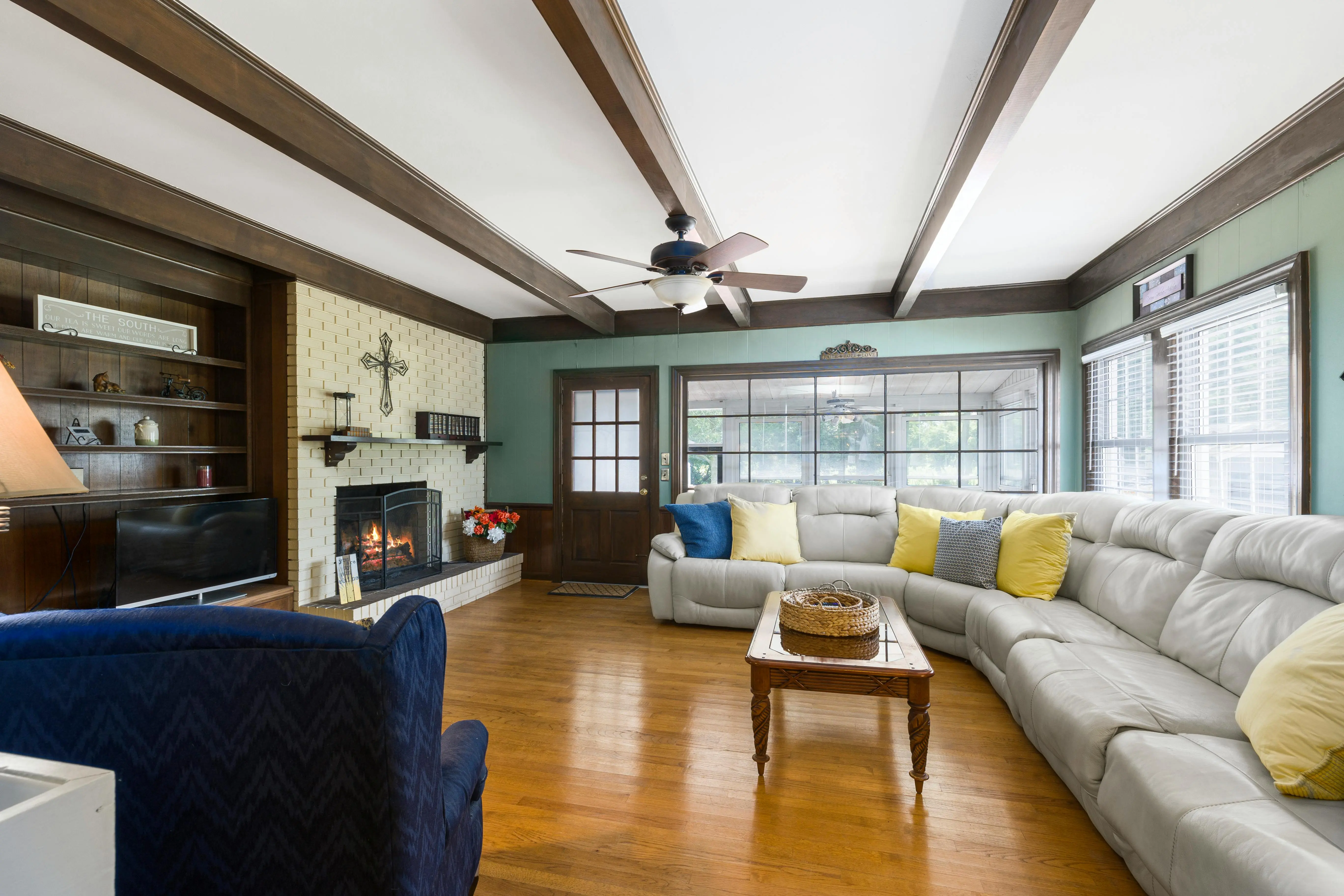blue sectional sofa Spacious living room featuring a cozy sectional sofa and fireplace, perfect for relaxation.