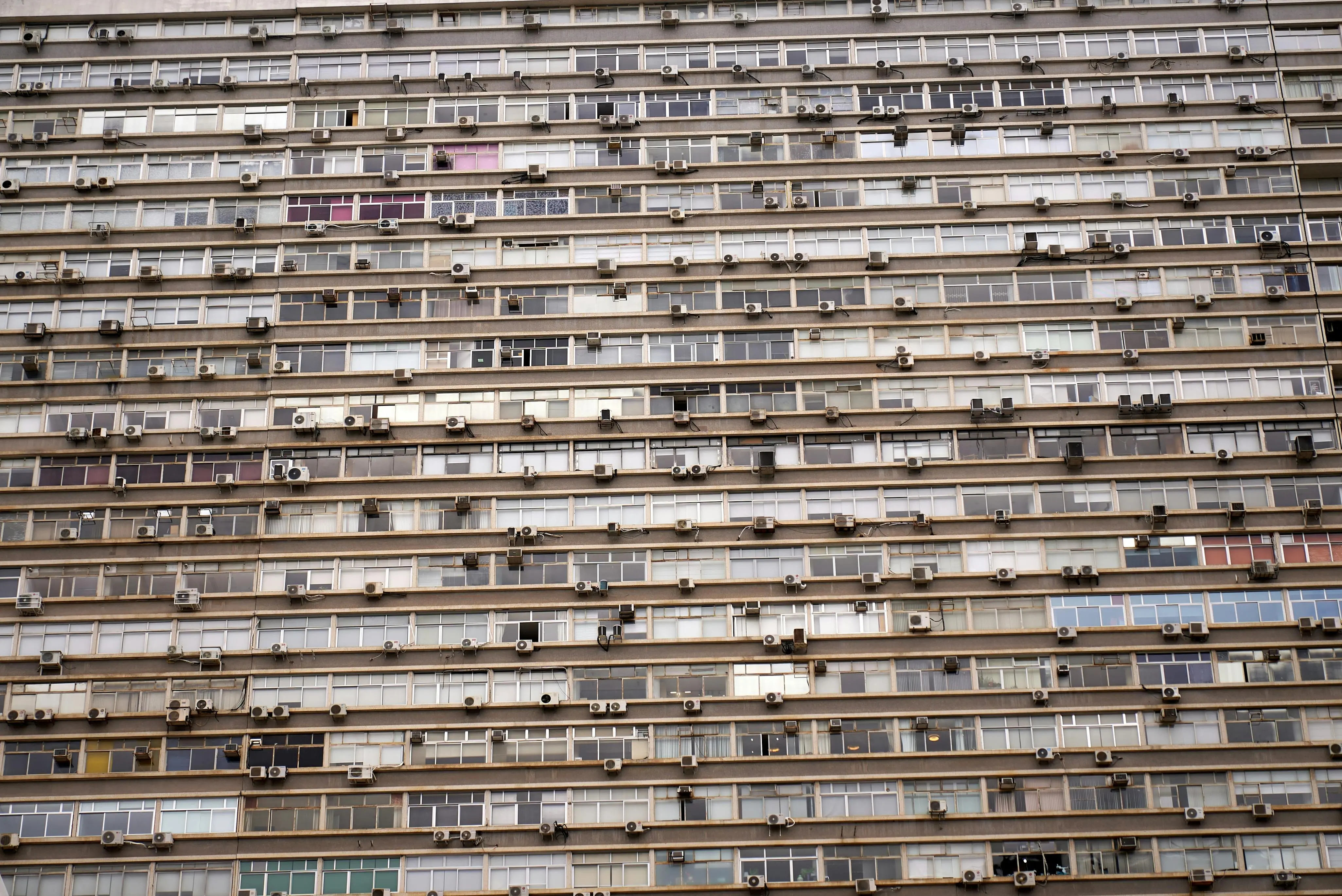 ac stopped working A detailed view of a high-rise building facade filled with air conditioning units.