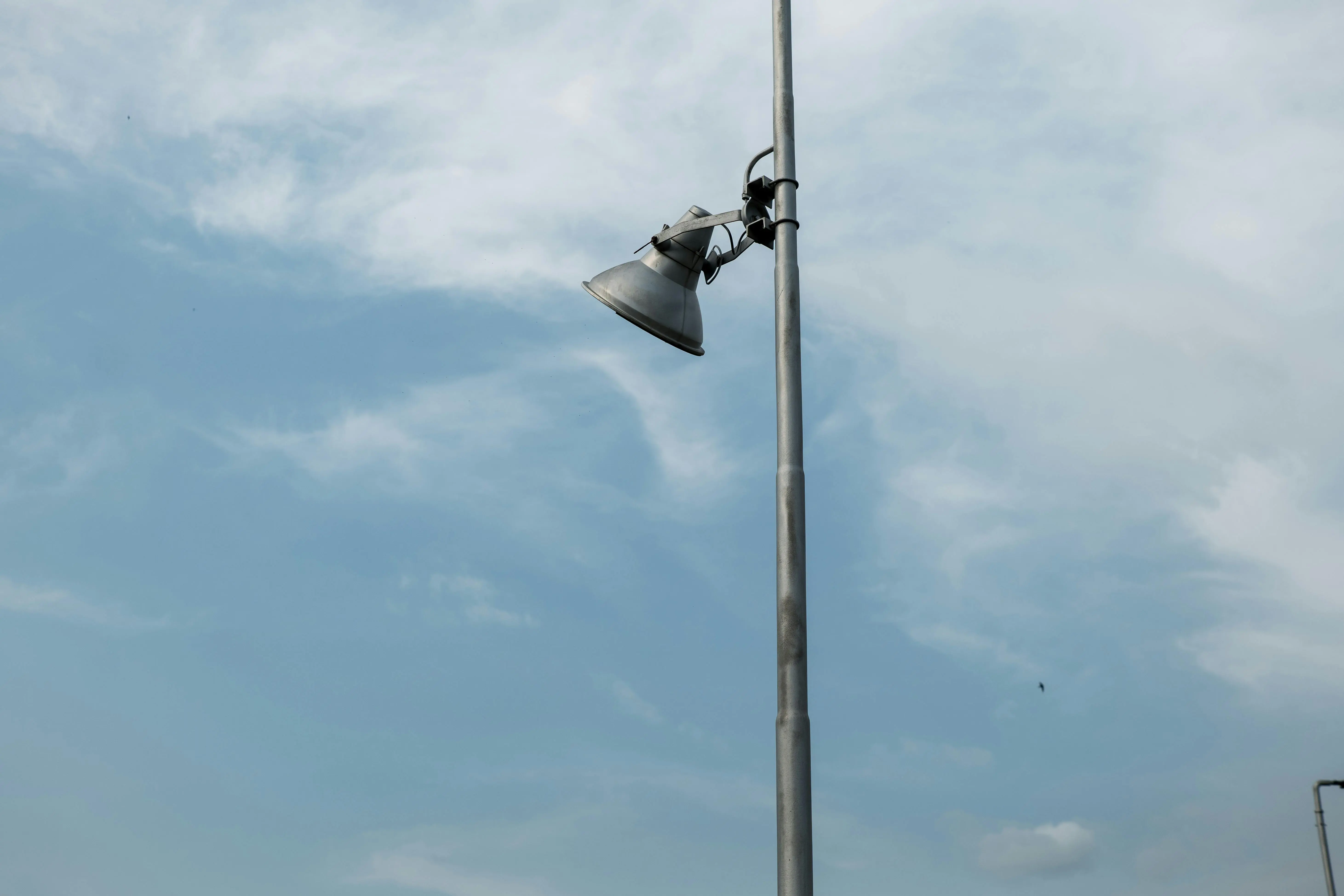 tall table lamps A solitary street light against a serene blue sky with scattered clouds.