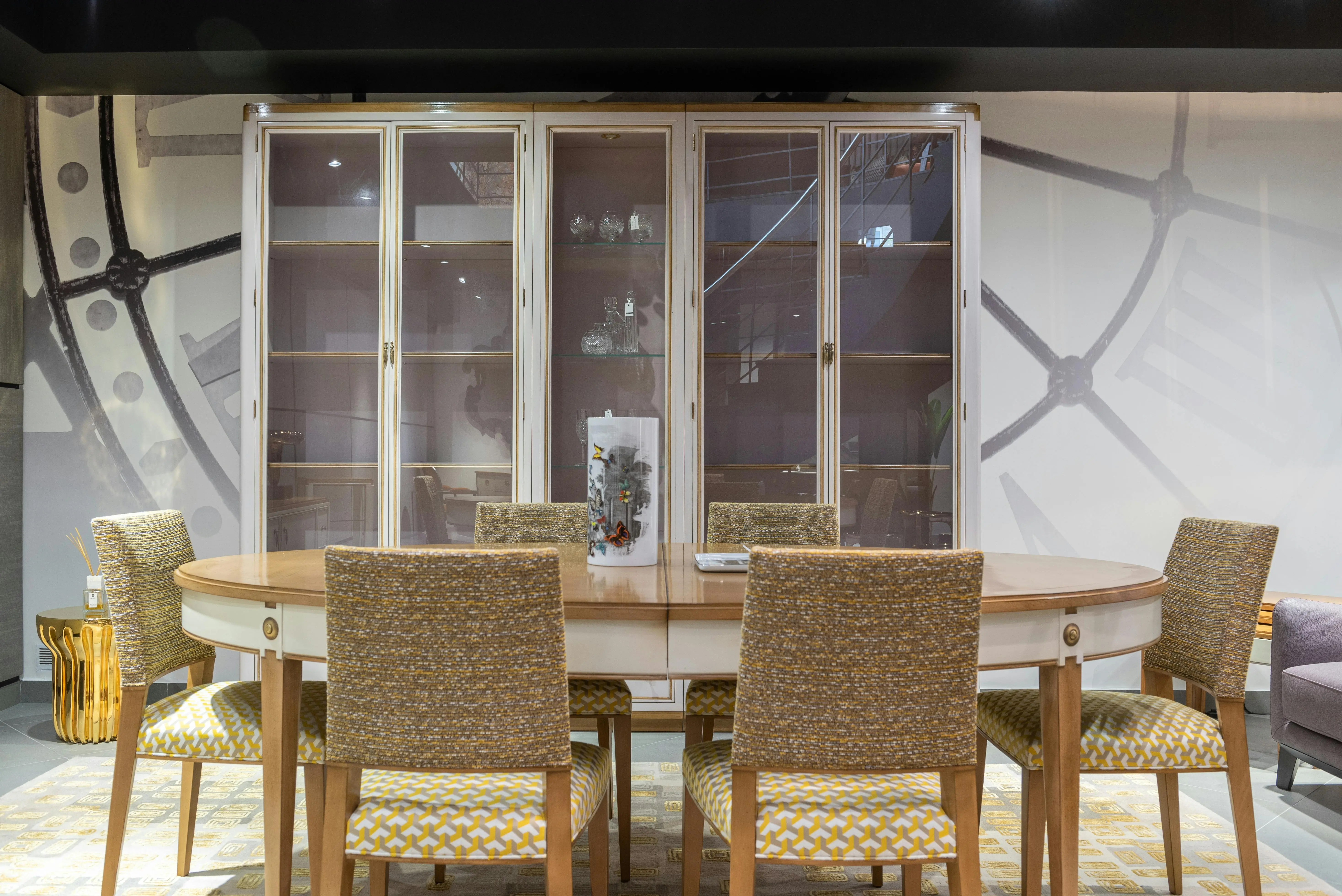 tiny home tips and tricks Elegant dining room setting with glass cabinet, table, and cushioned chairs showcasing modern interior design.