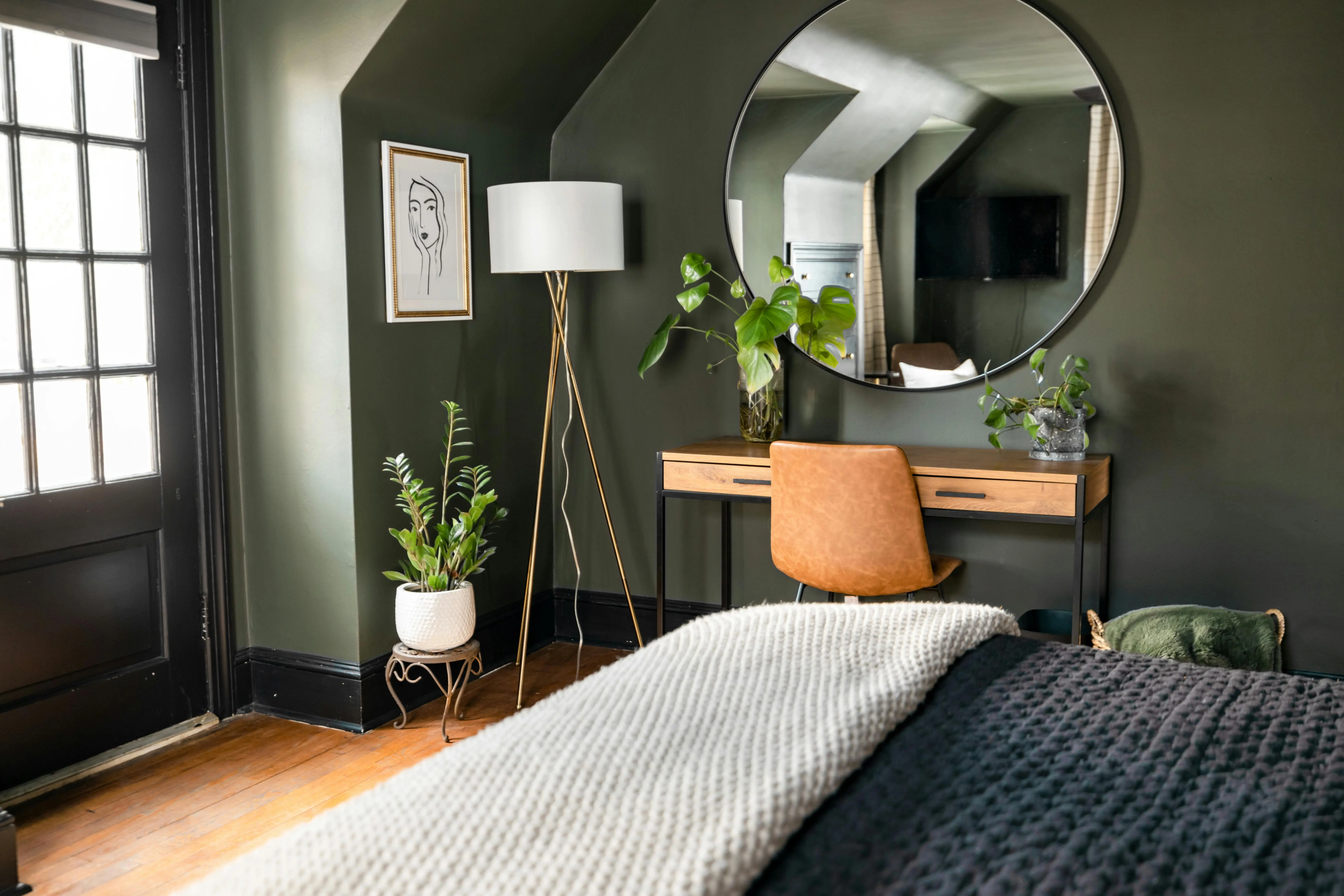 dark gray paint Elegant and cozy bedroom featuring green walls, modern decor, and natural lighting for a peaceful ambiance.