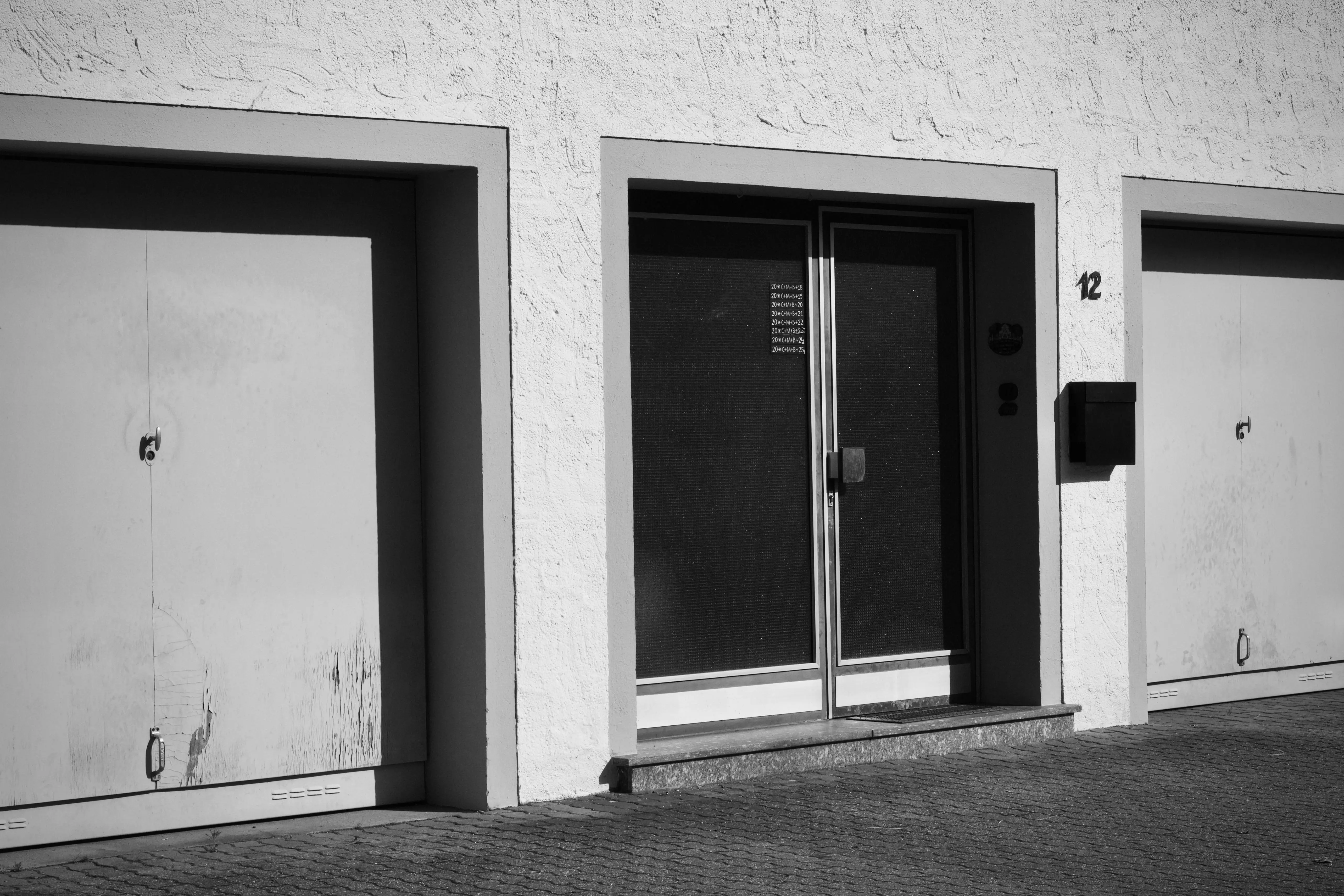 garage doors with windows Monochrome photo of an urban building facade with garages and doors.