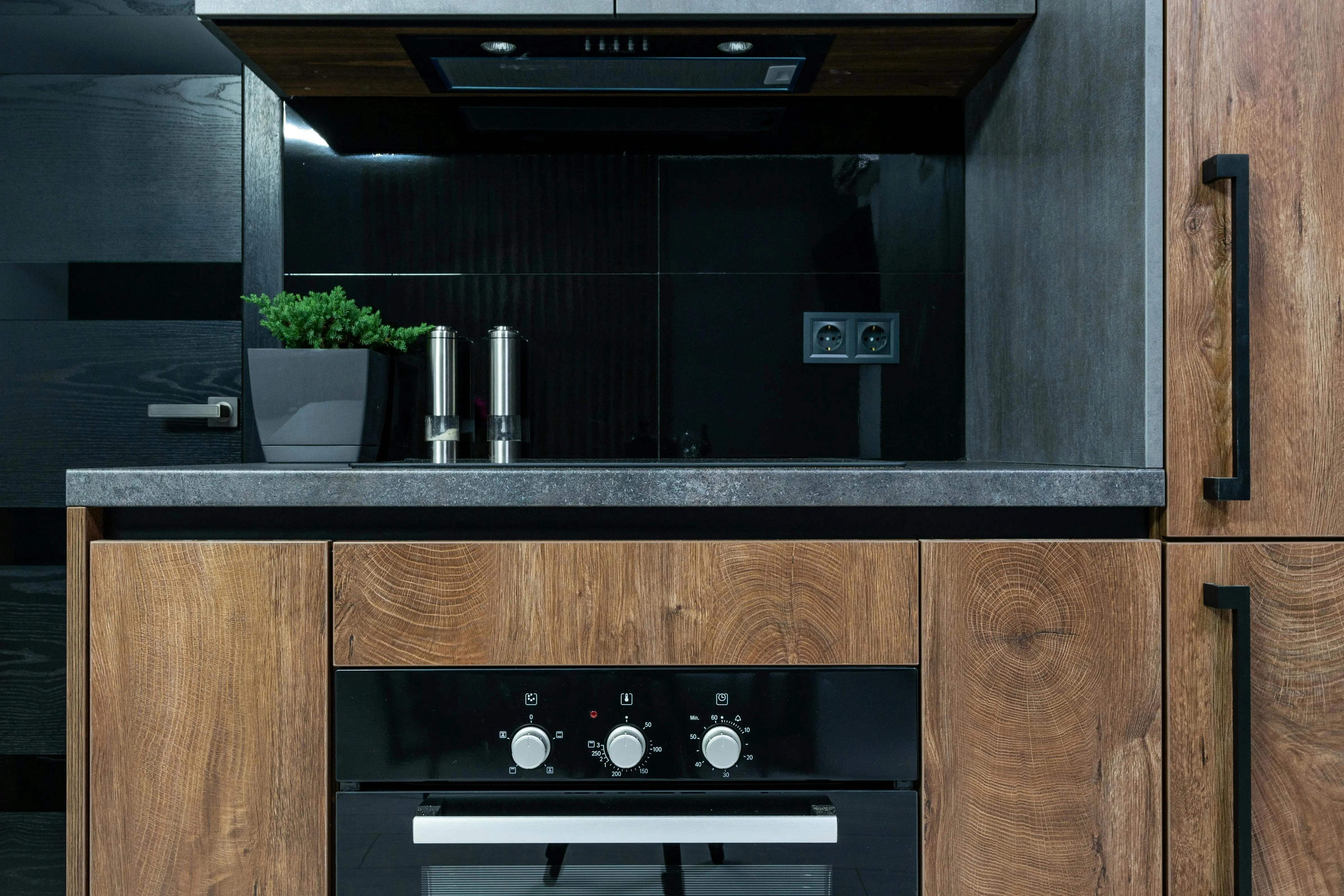 glass on tile Stylish kitchen interior featuring wooden cabinets, black accents, and modern appliances.