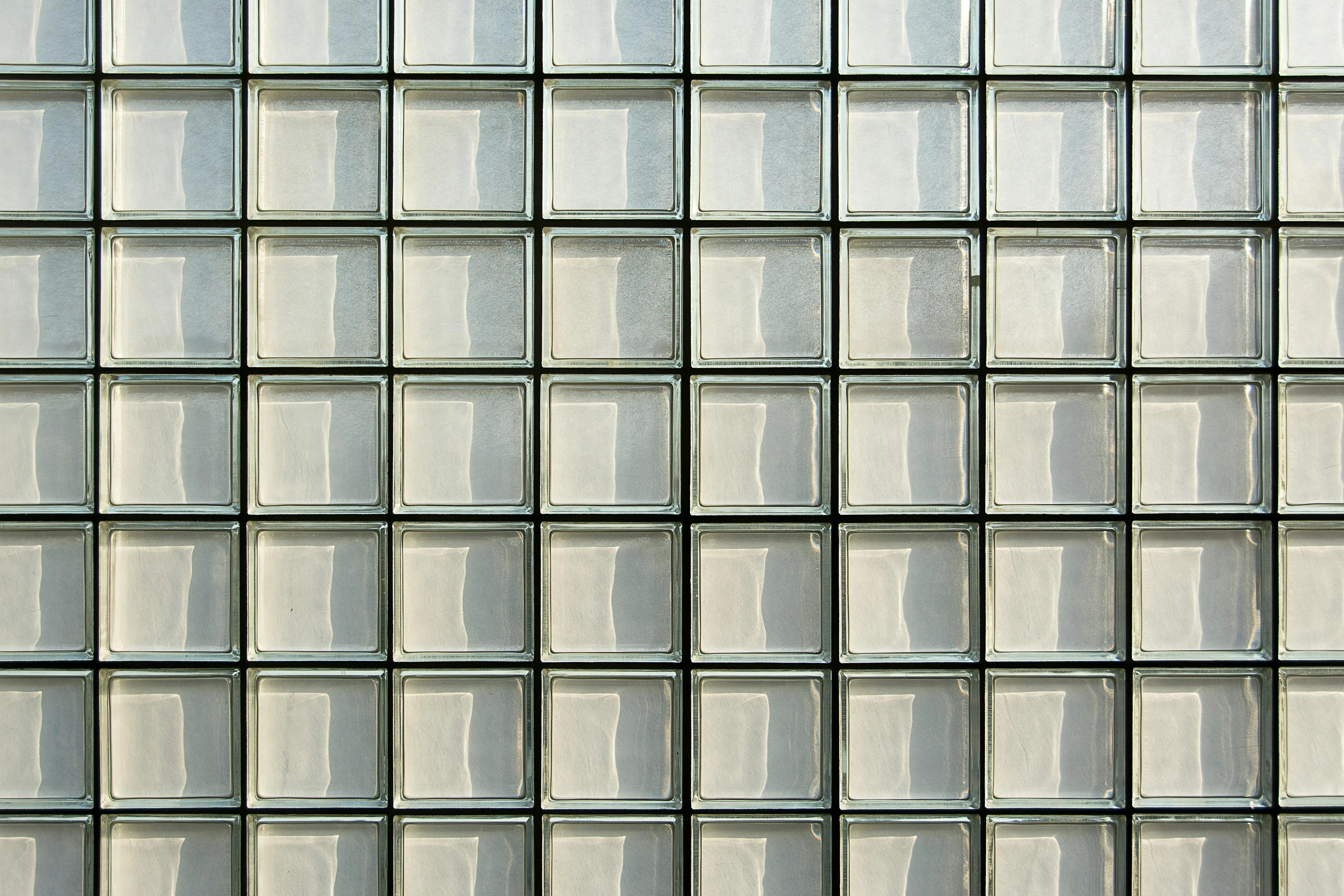 glass on tile Close-up of a geometric glass block facade showcasing a repetitive pattern and modern architecture.