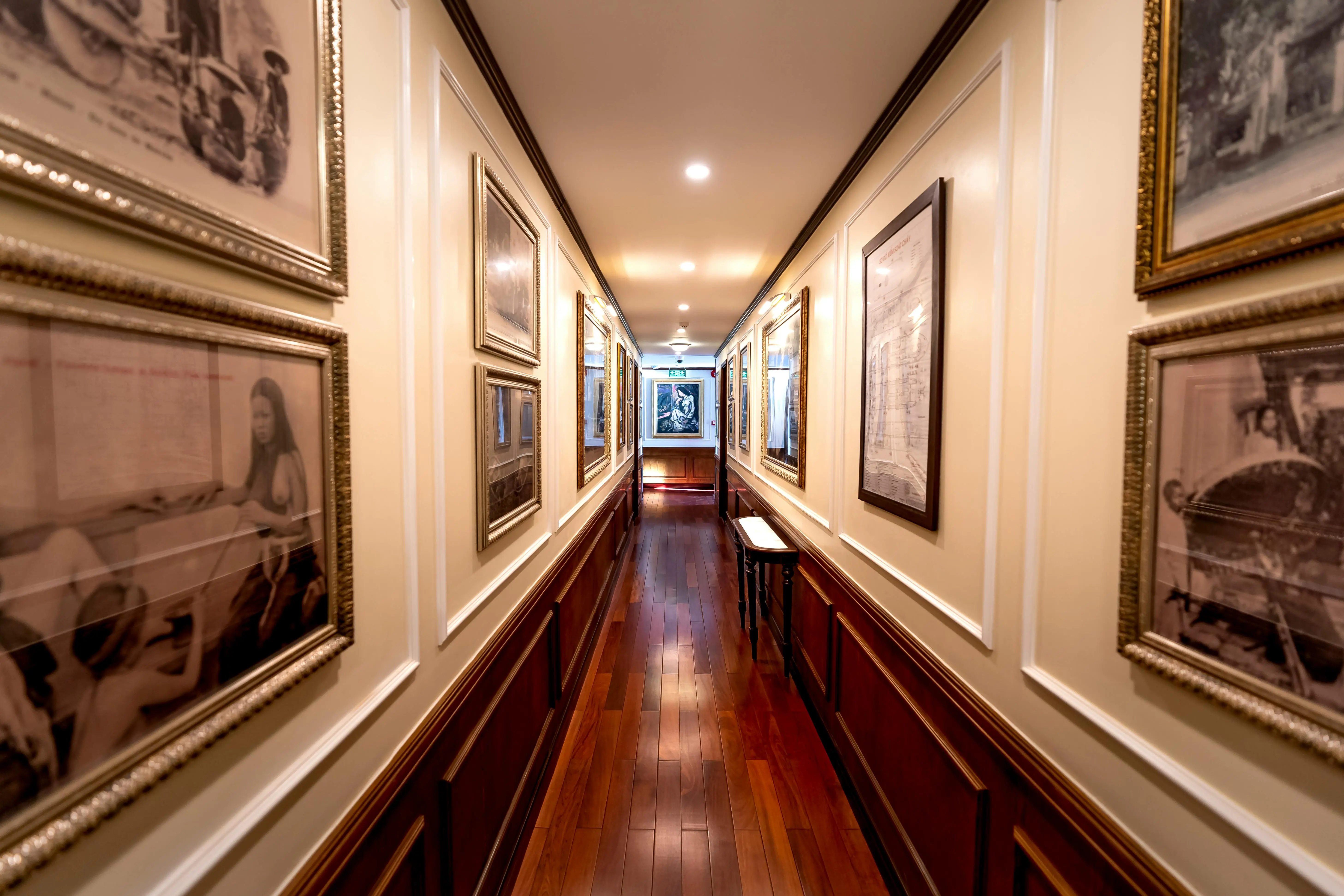 hallway art A stylish corridor featuring framed art on illuminated walls and a polished wooden floor.