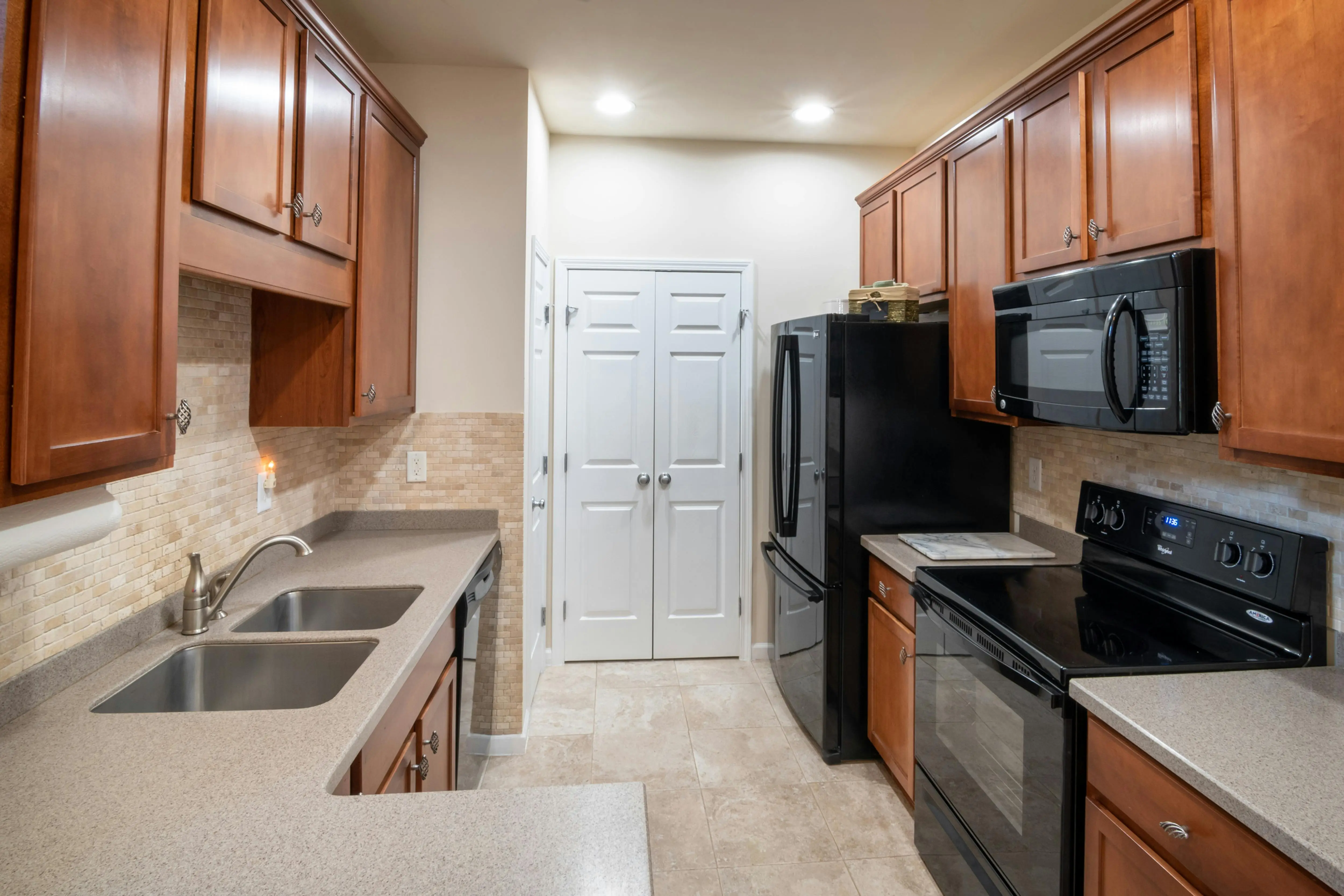 maple cabinets Spacious modern kitchen with wood cabinets, sleek countertops, and stainless steel appliances.