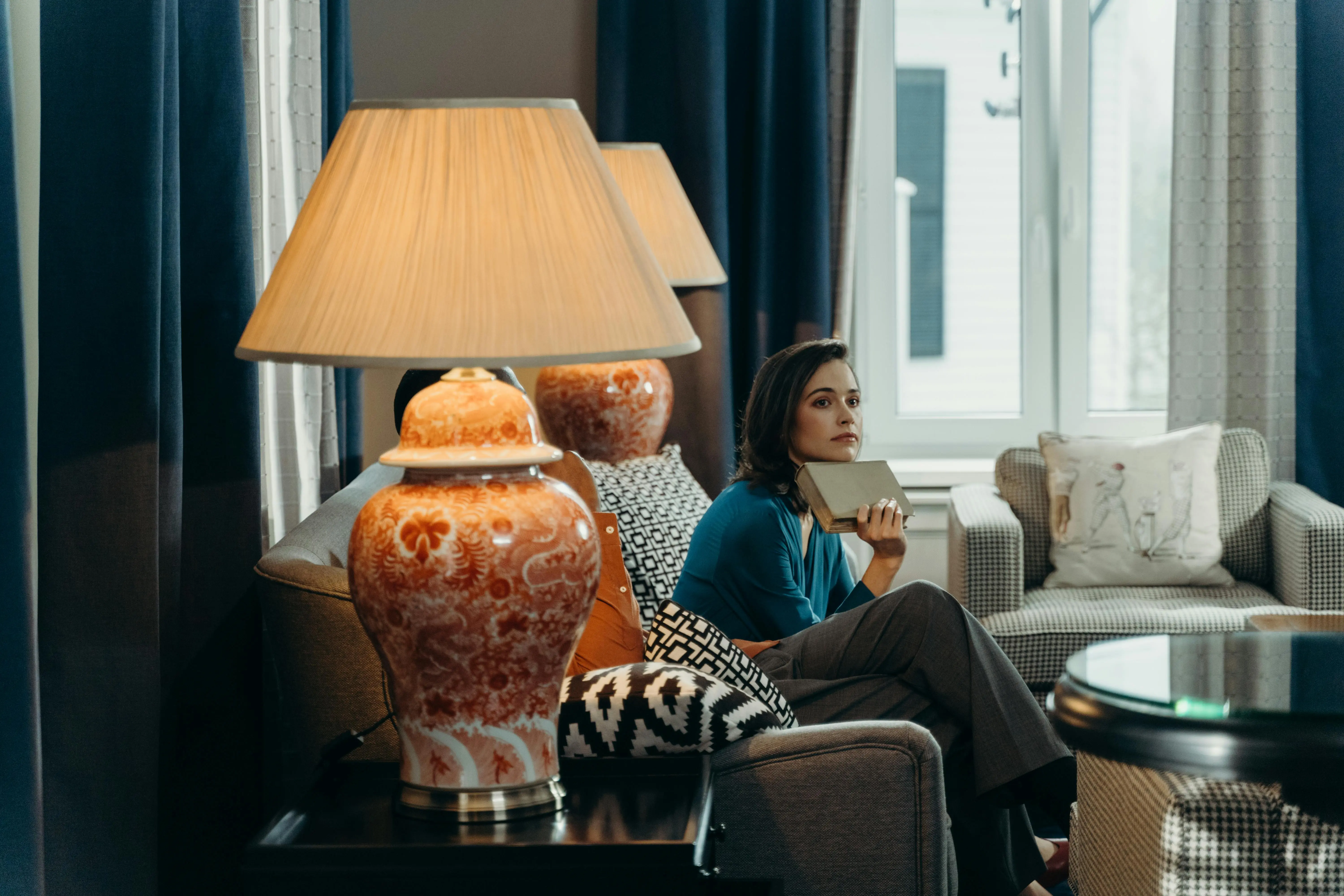 tall table lamps Woman relaxing with a book in a stylish, cozy living room. Elegant decor and serene lighting.
