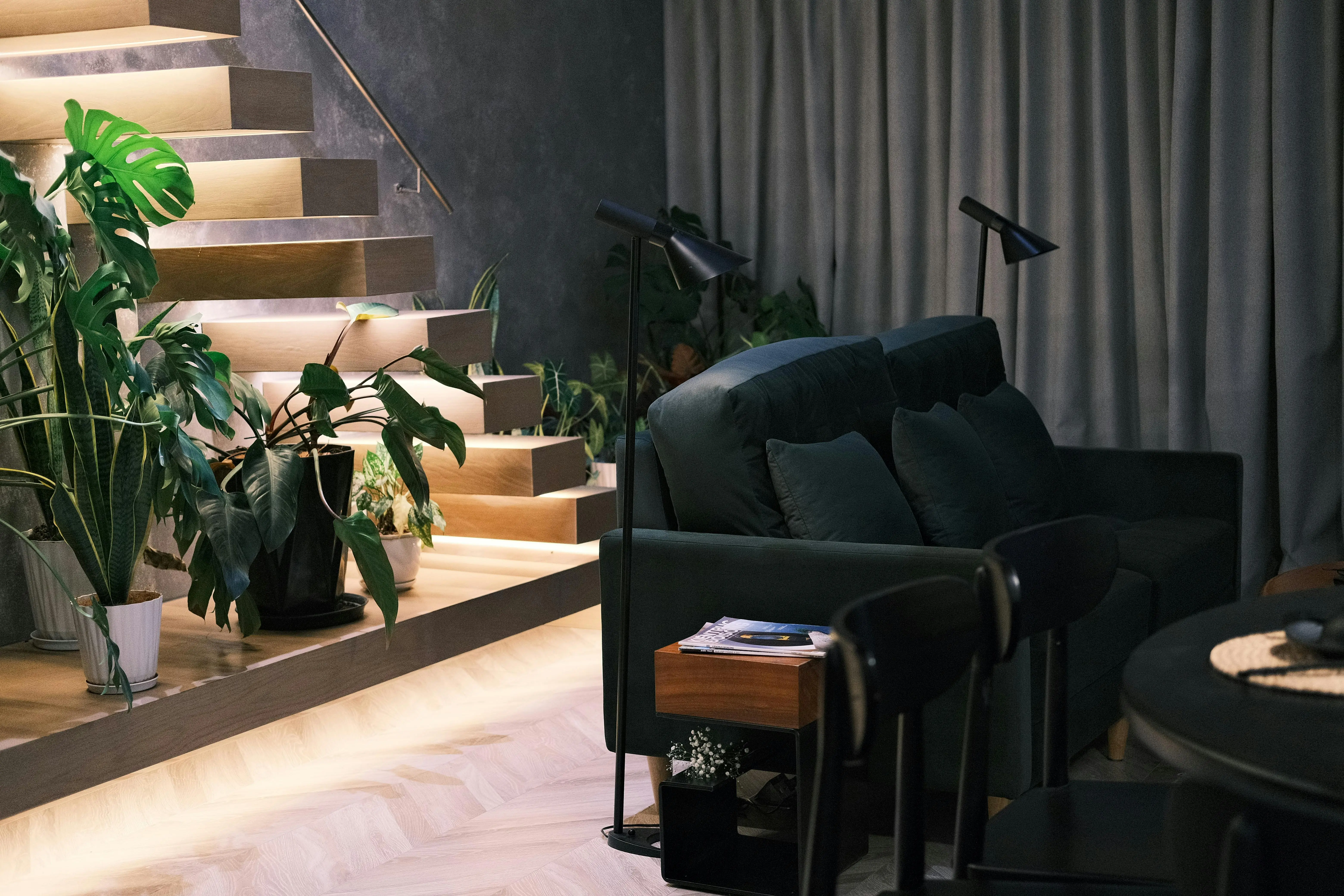 large indoor plants Stylish living room with greenery, stairs, and soft lighting. Cozy and modern decor.