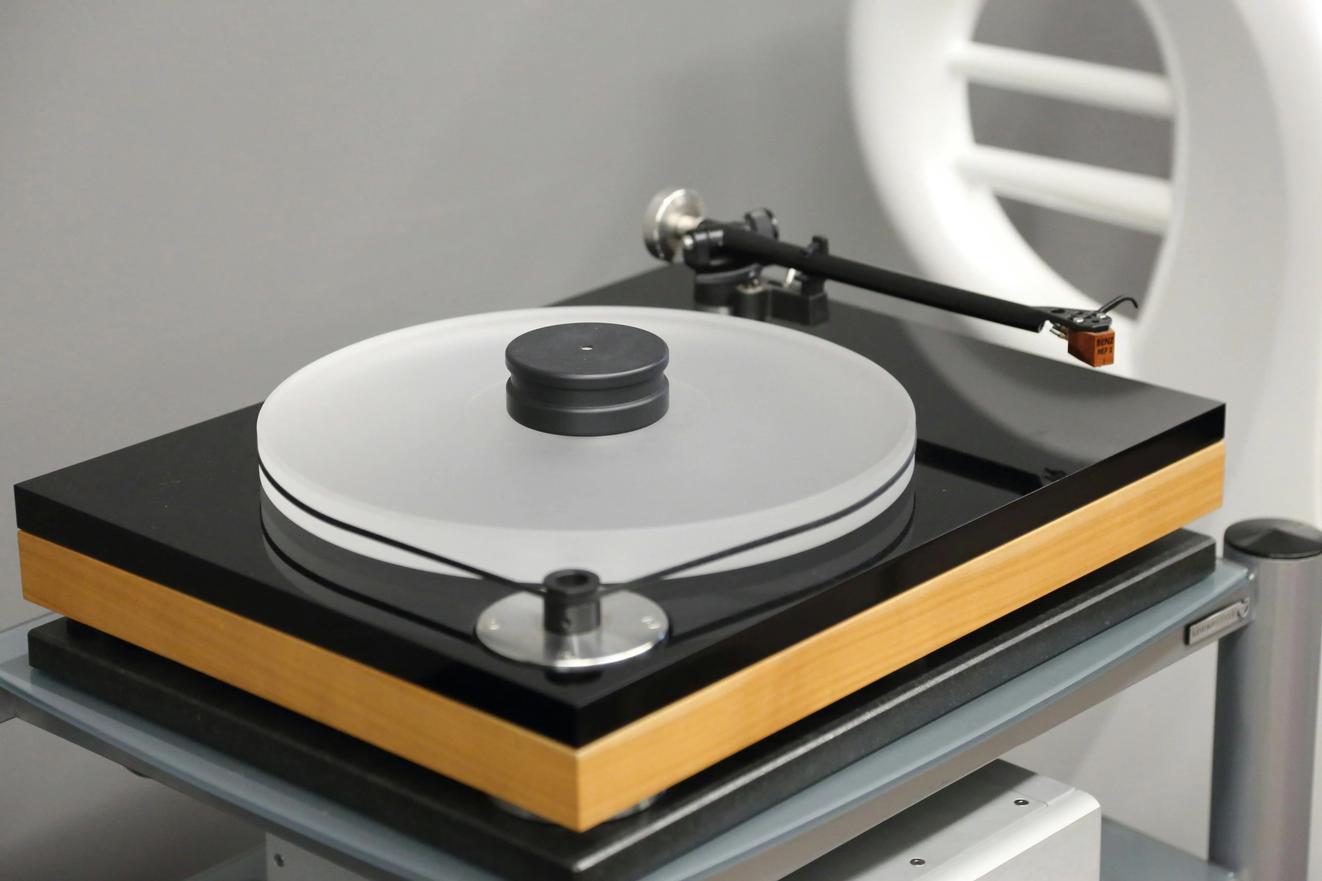 turntable and vinyl stand Close-up view of a sleek modern turntable with a wooden base and black accents.