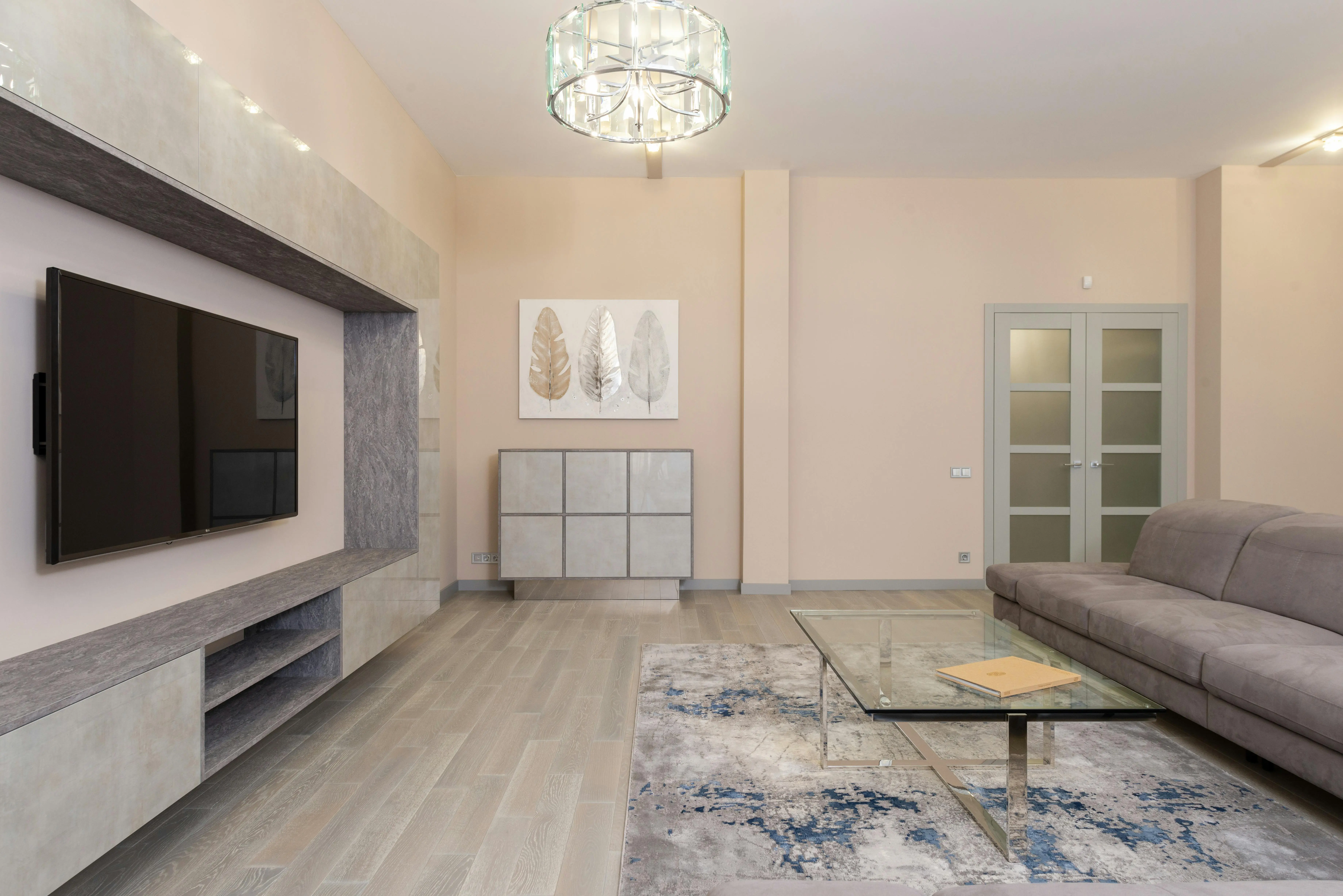 wall sculpture Comfortable couch on rug near glass table against wall with modern TV in stylish living room with door and cupboard