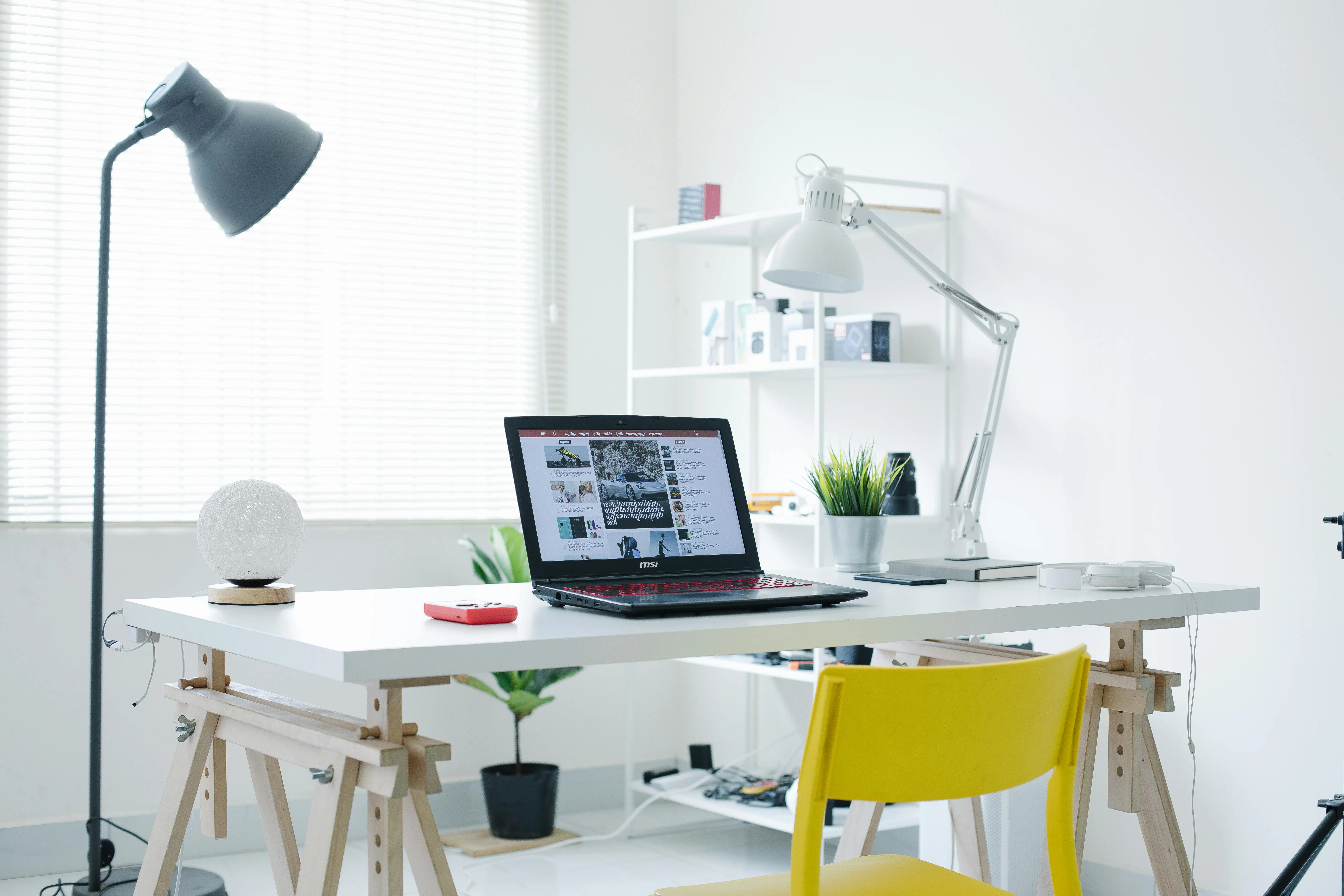 white lamp A bright white home office featuring a laptop and sleek contemporary design elements.