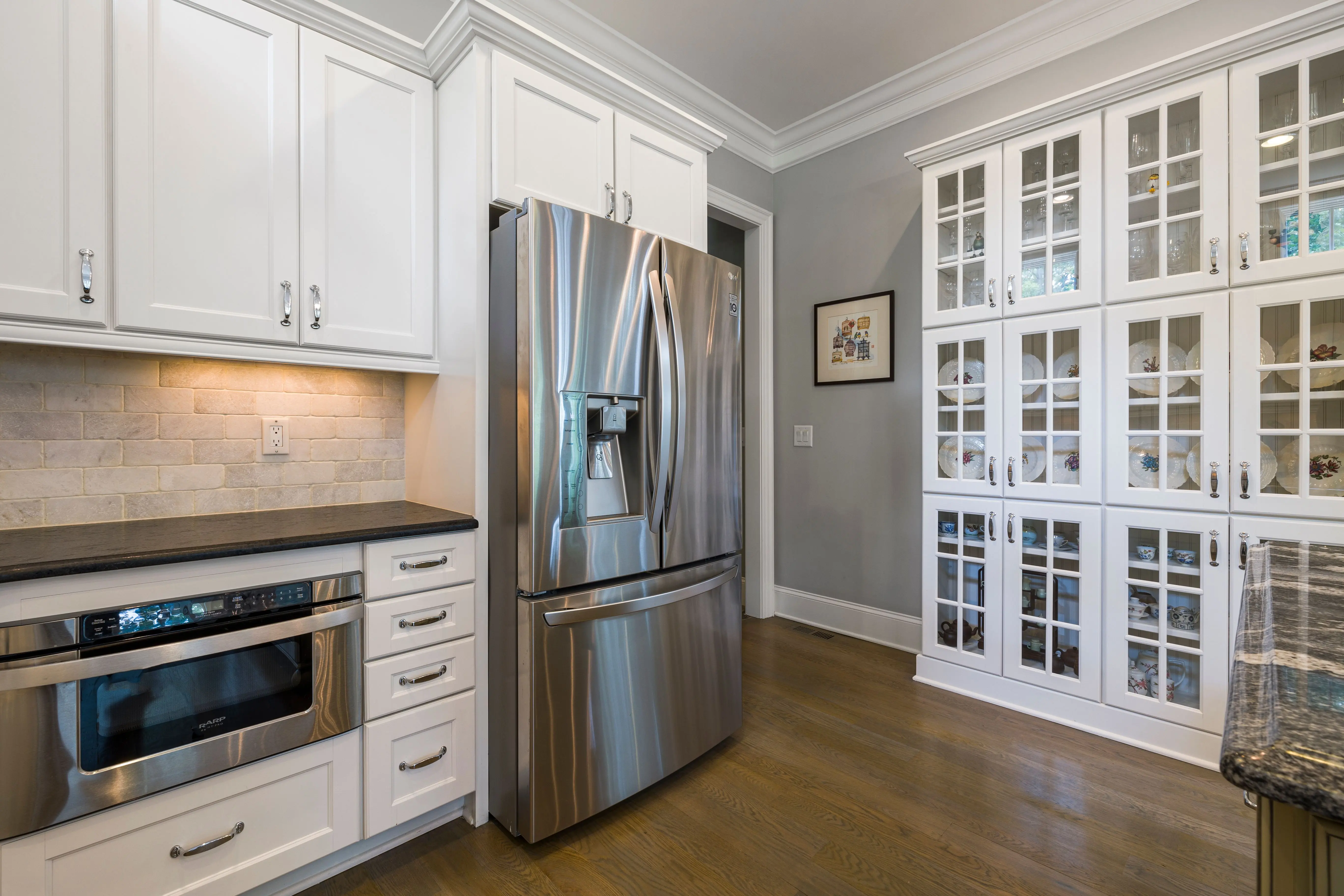 white shaker cabinet Contemporary kitchen interior featuring stainless steel fridge and white cabinets.