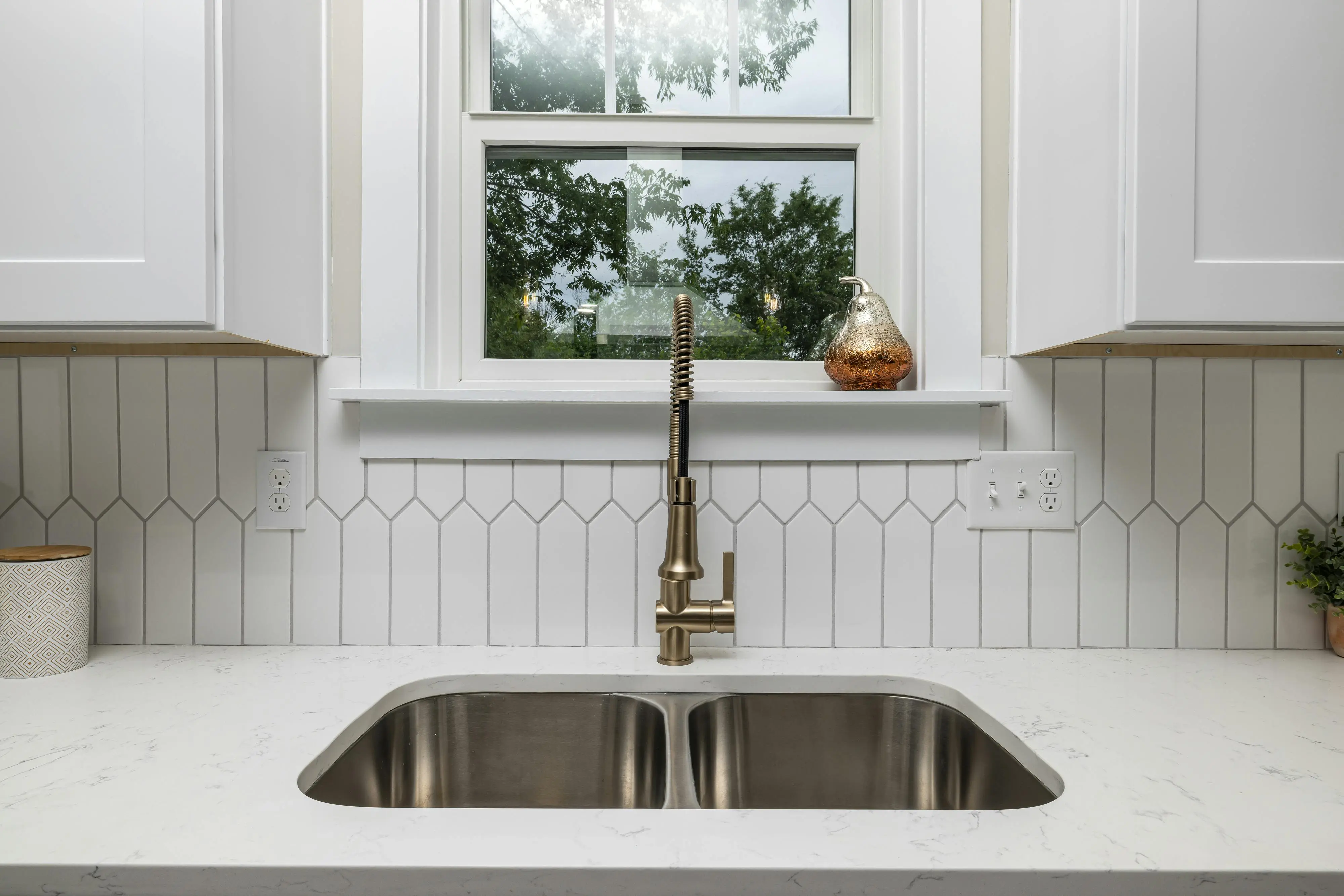 sink parts Contemporary kitchen design featuring white cabinets and a stainless steel sink with a minimalist faucet.