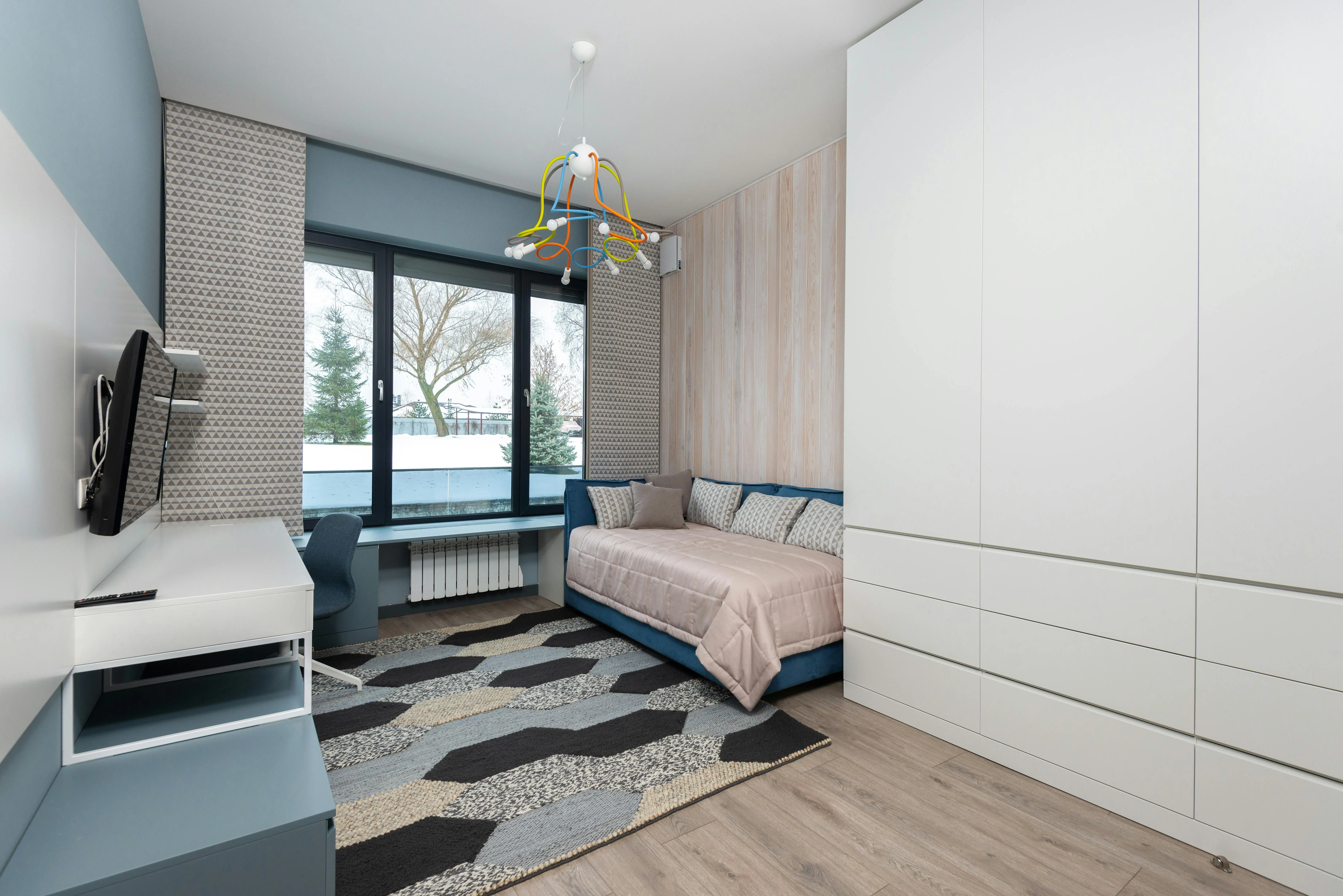 small sofa bed with storage Interior of cozy bedroom with sofa bed and big wardrobe placed in front of table and TV hanging on wall
