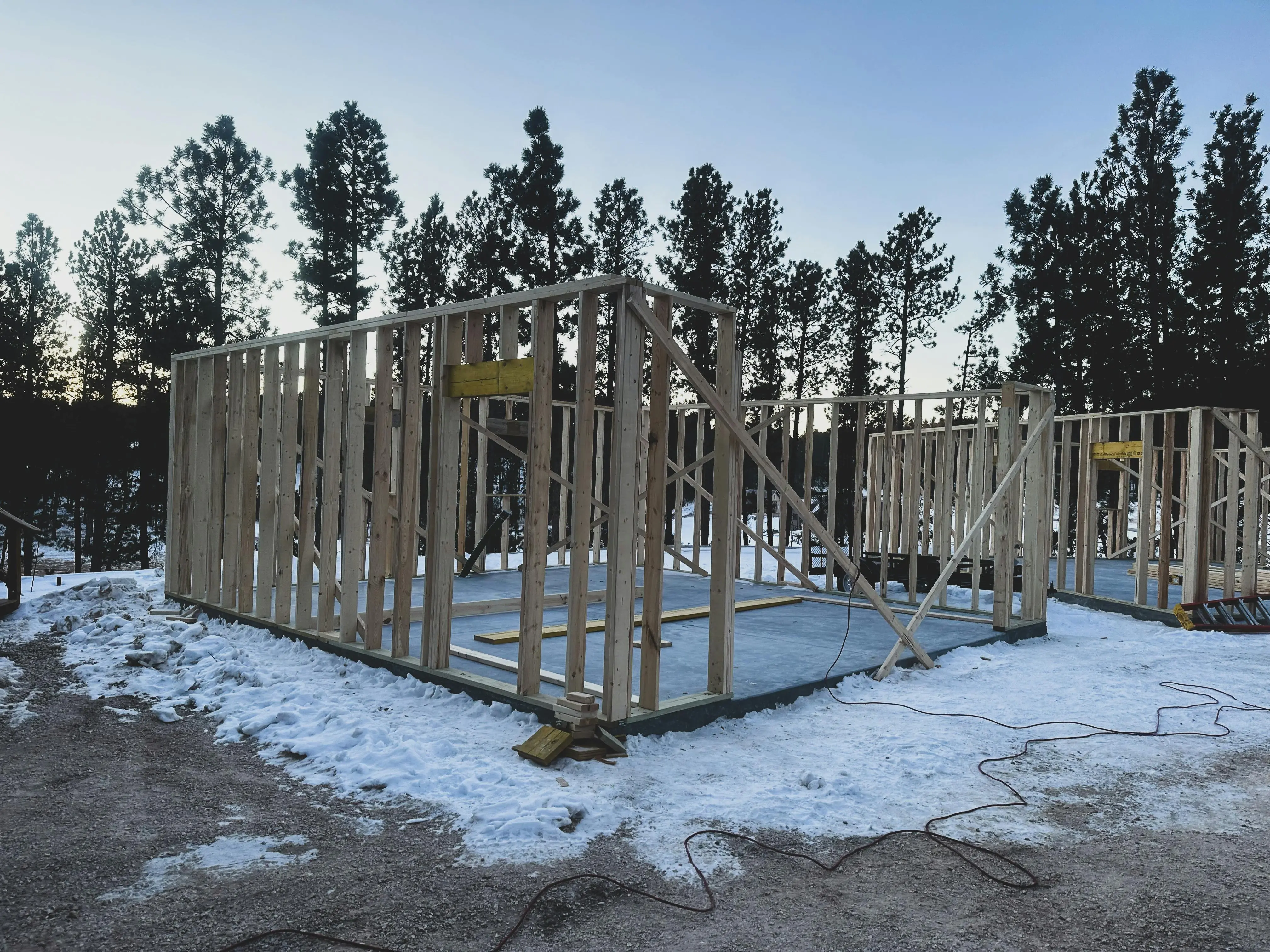 tiny home tips Wooden frames of a house under construction on a snowy winter morning in Custer, SD.