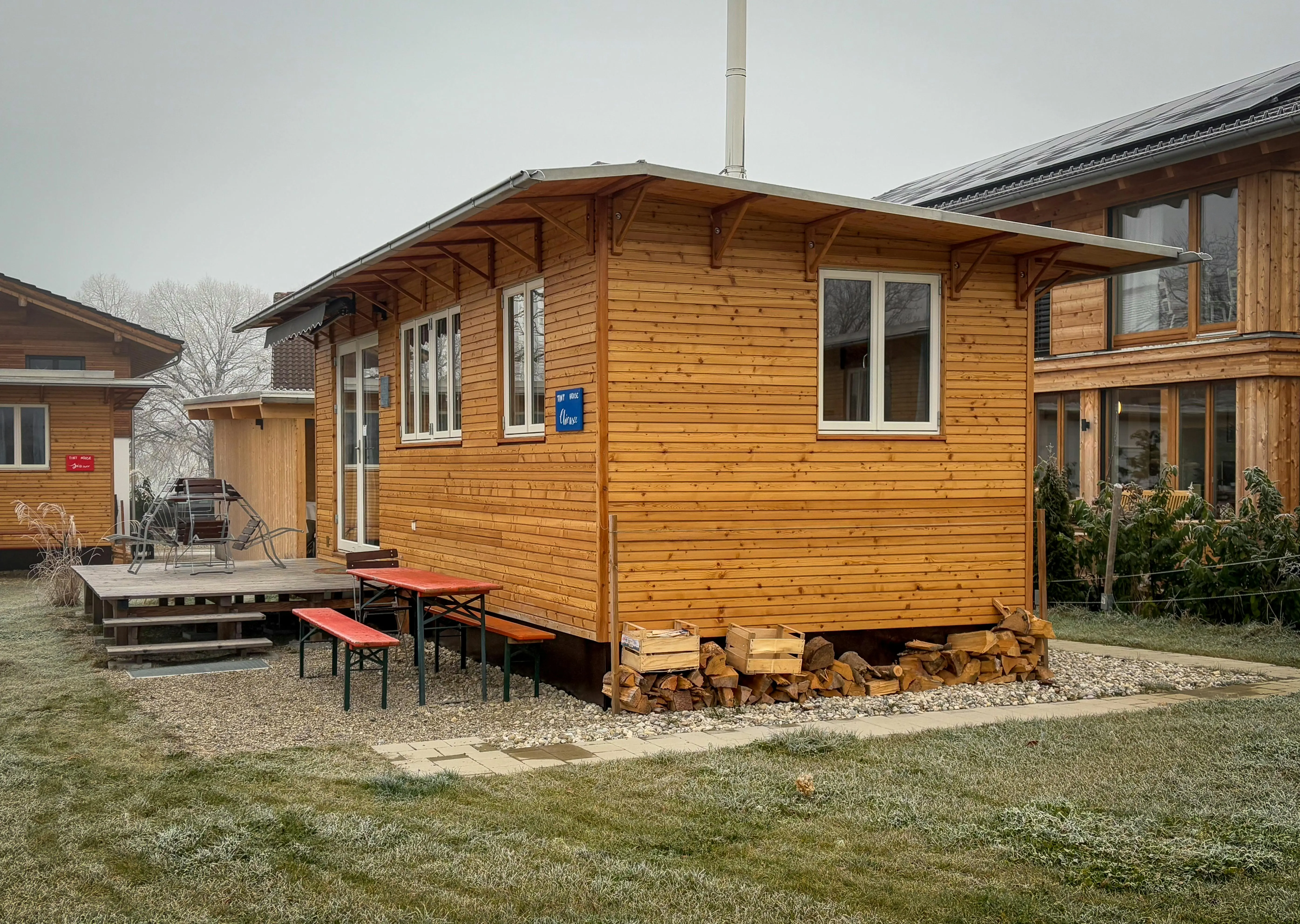 tiny home tips and tricks A charming wooden cabin with a small porch in a peaceful countryside location.