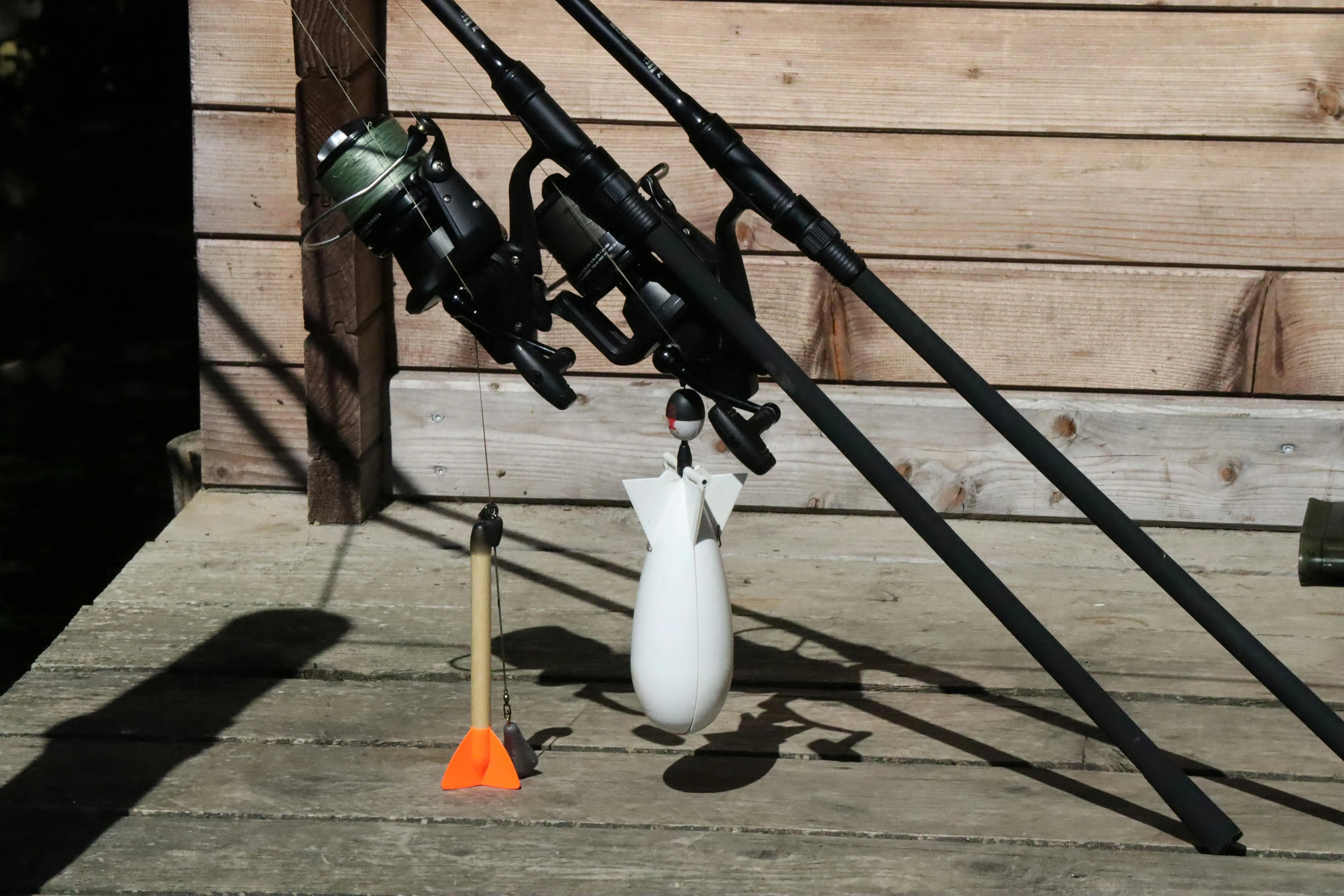 mouse bait stations Close-up of fishing rods and accessories on a dock in sunlight.