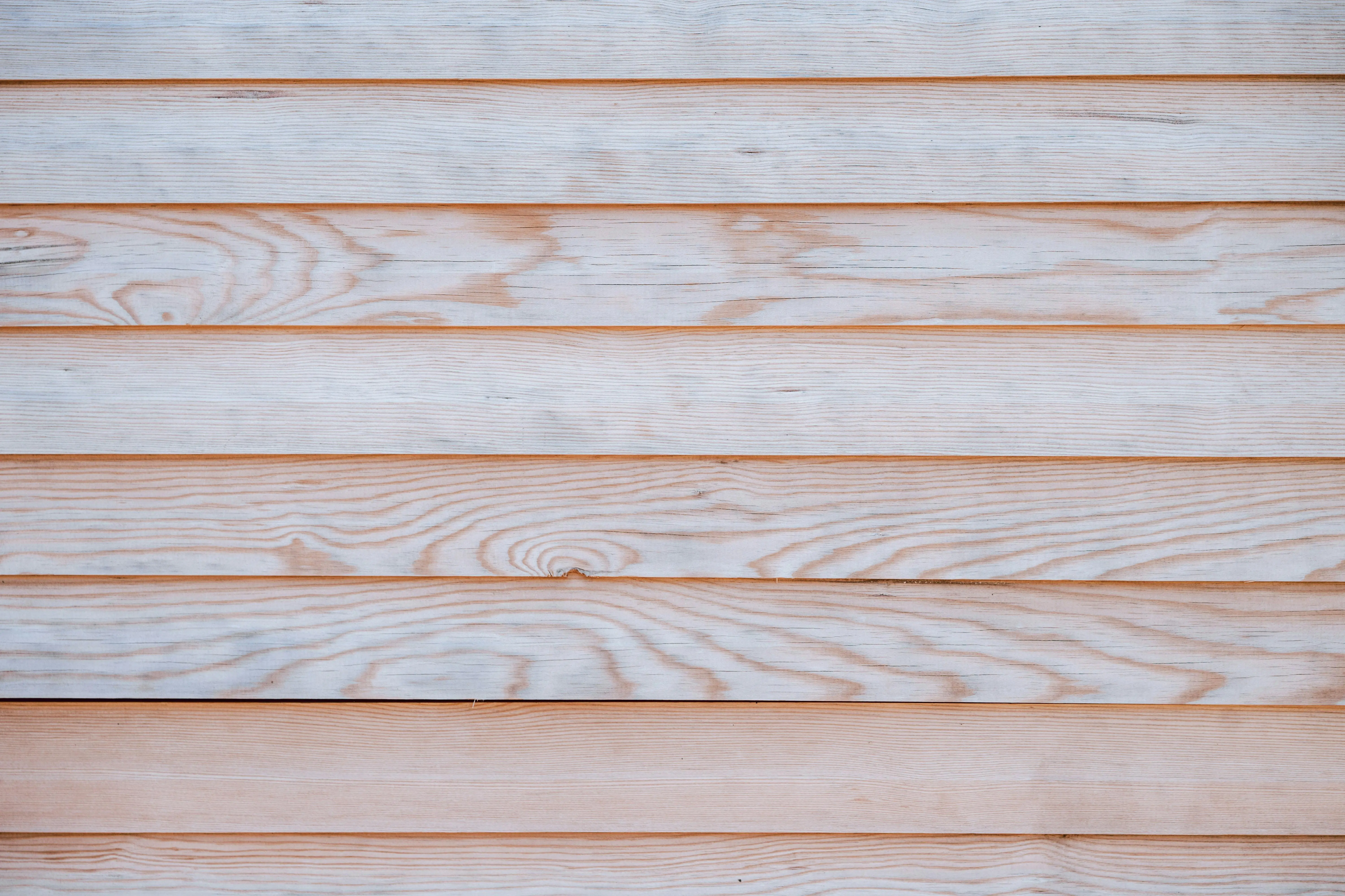 wood siding panels Close-up of a light wooden wall showcasing a natural grain pattern and texture, ideal for design backdrops.